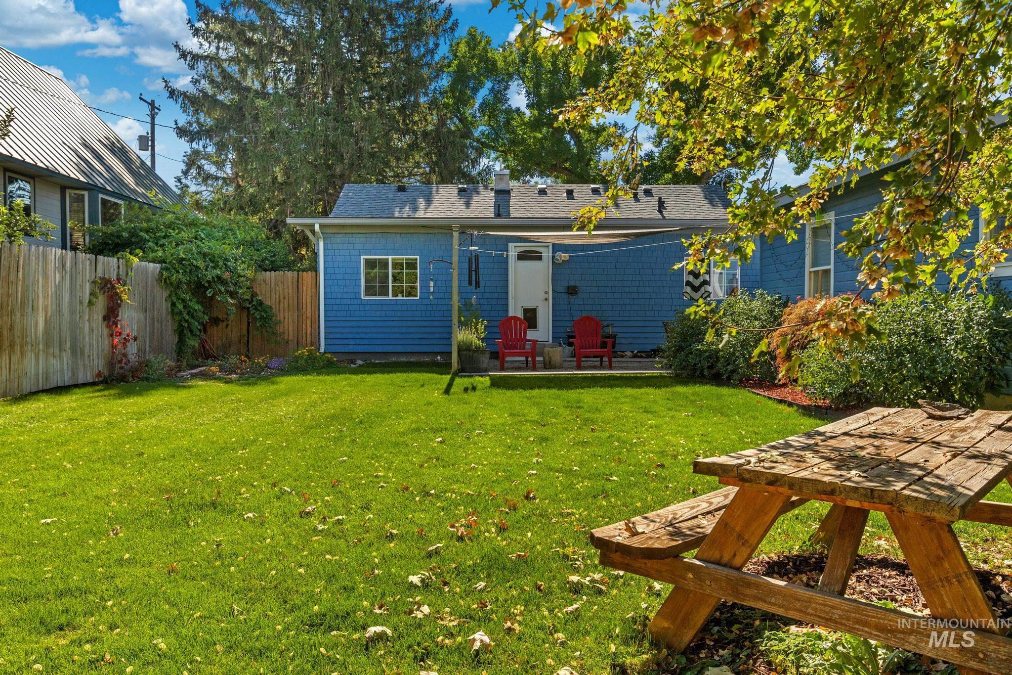 Back of property with a patio area, a shingled roof, and a chimney