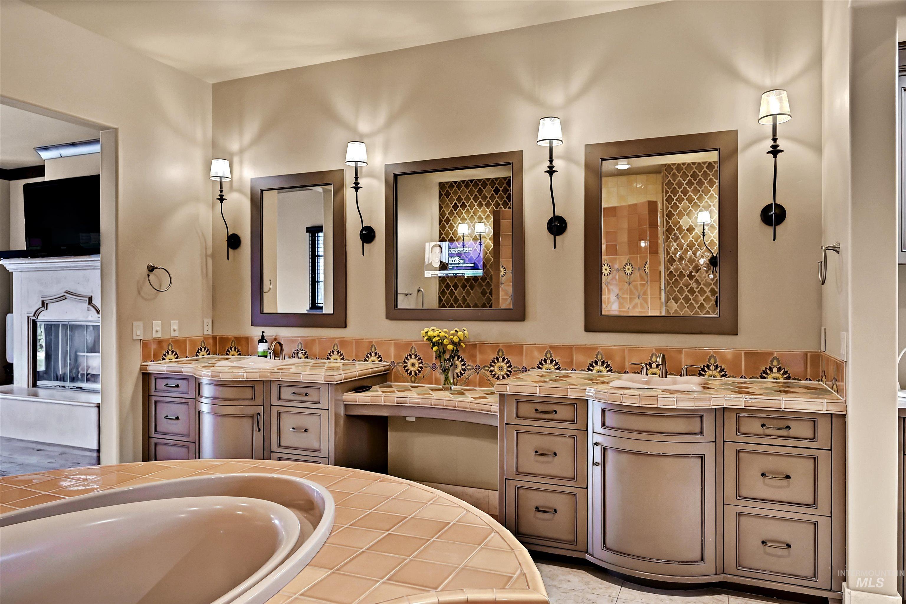 Full bath featuring double vanity and hidden television behind the vanity mirror