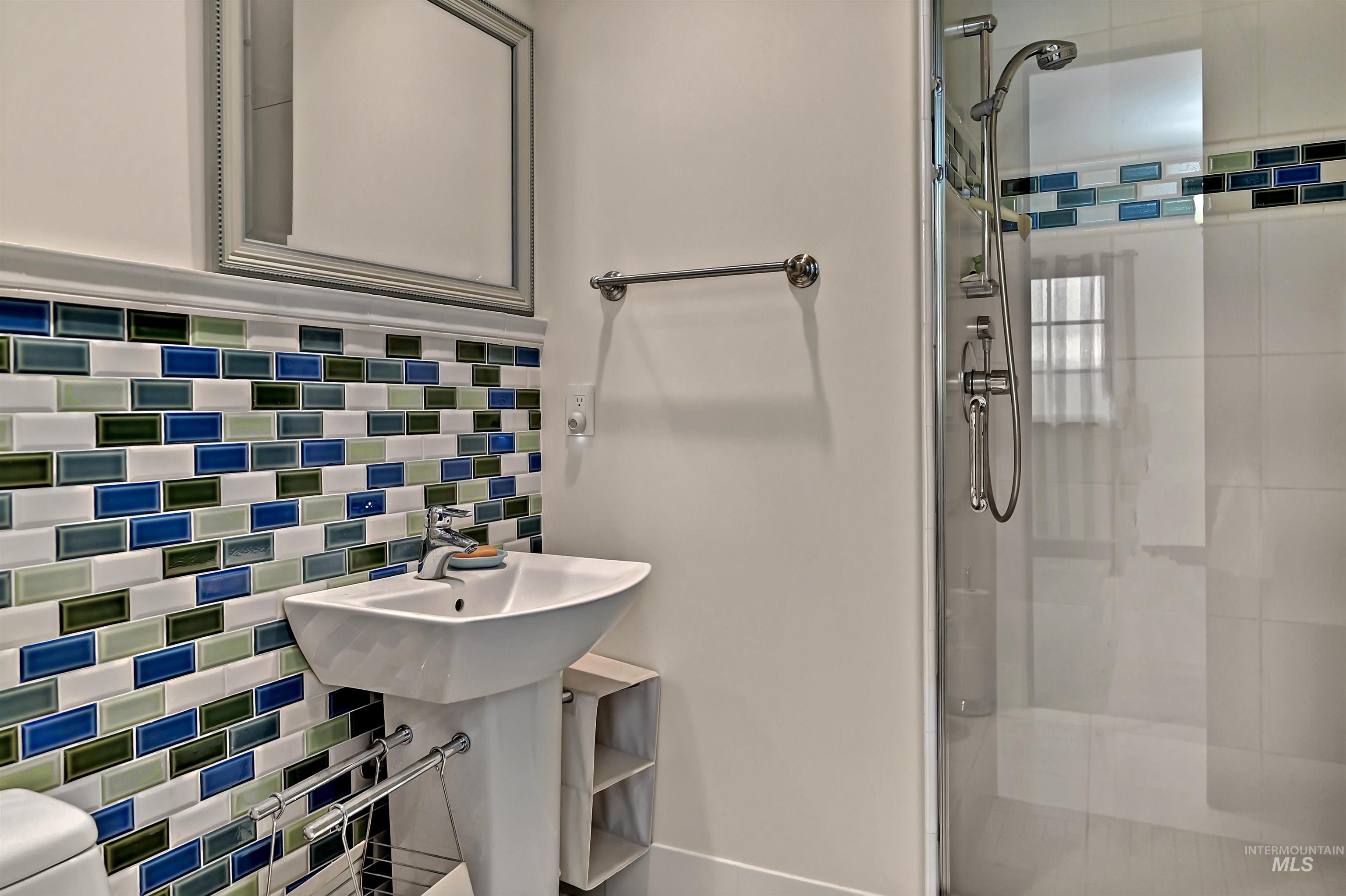 Full bathroom featuring a shower and tile walls