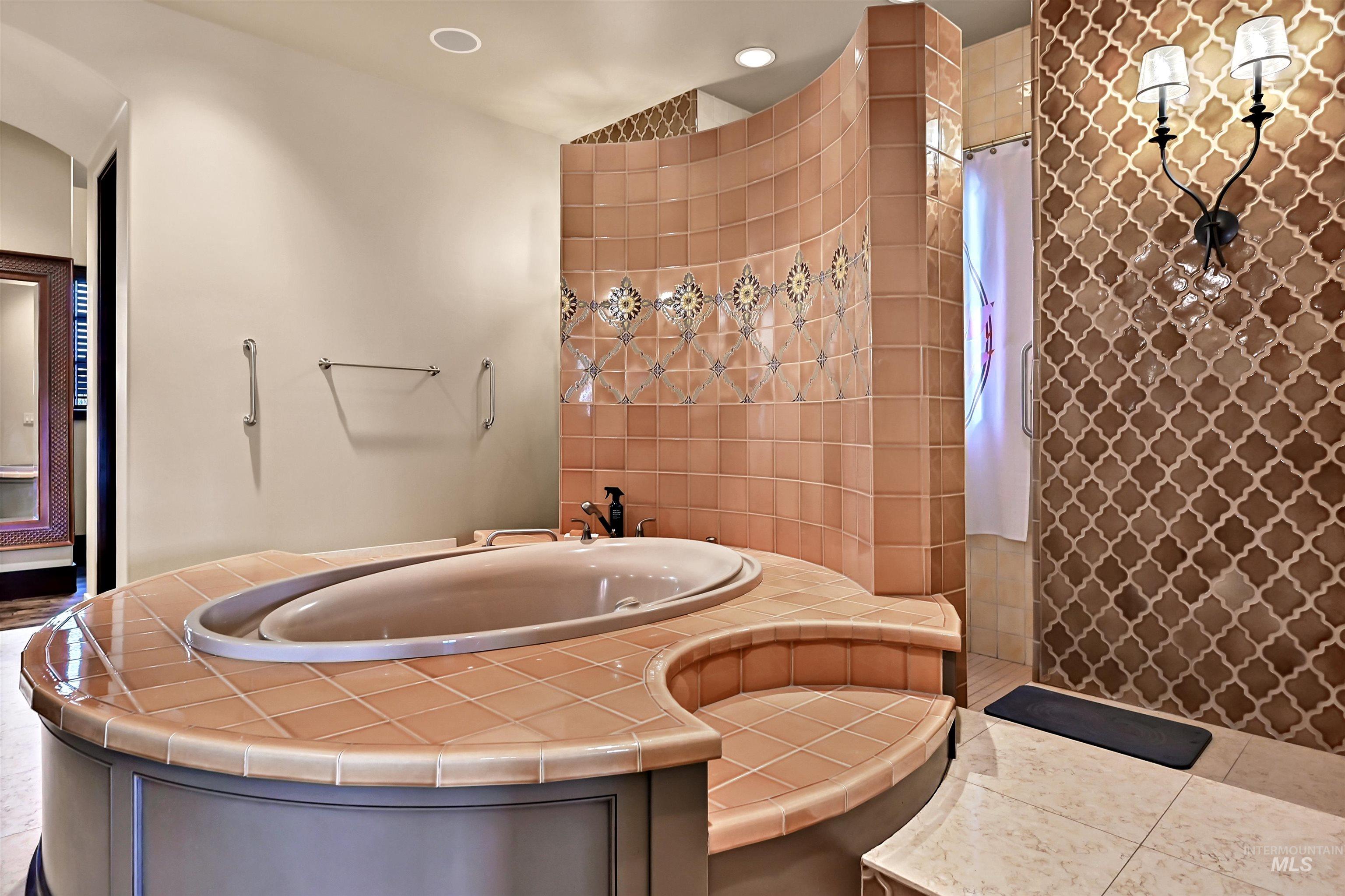 Bathroom with a walk in shower, a garden tub with ceiling-mounted water spout above the bathtub