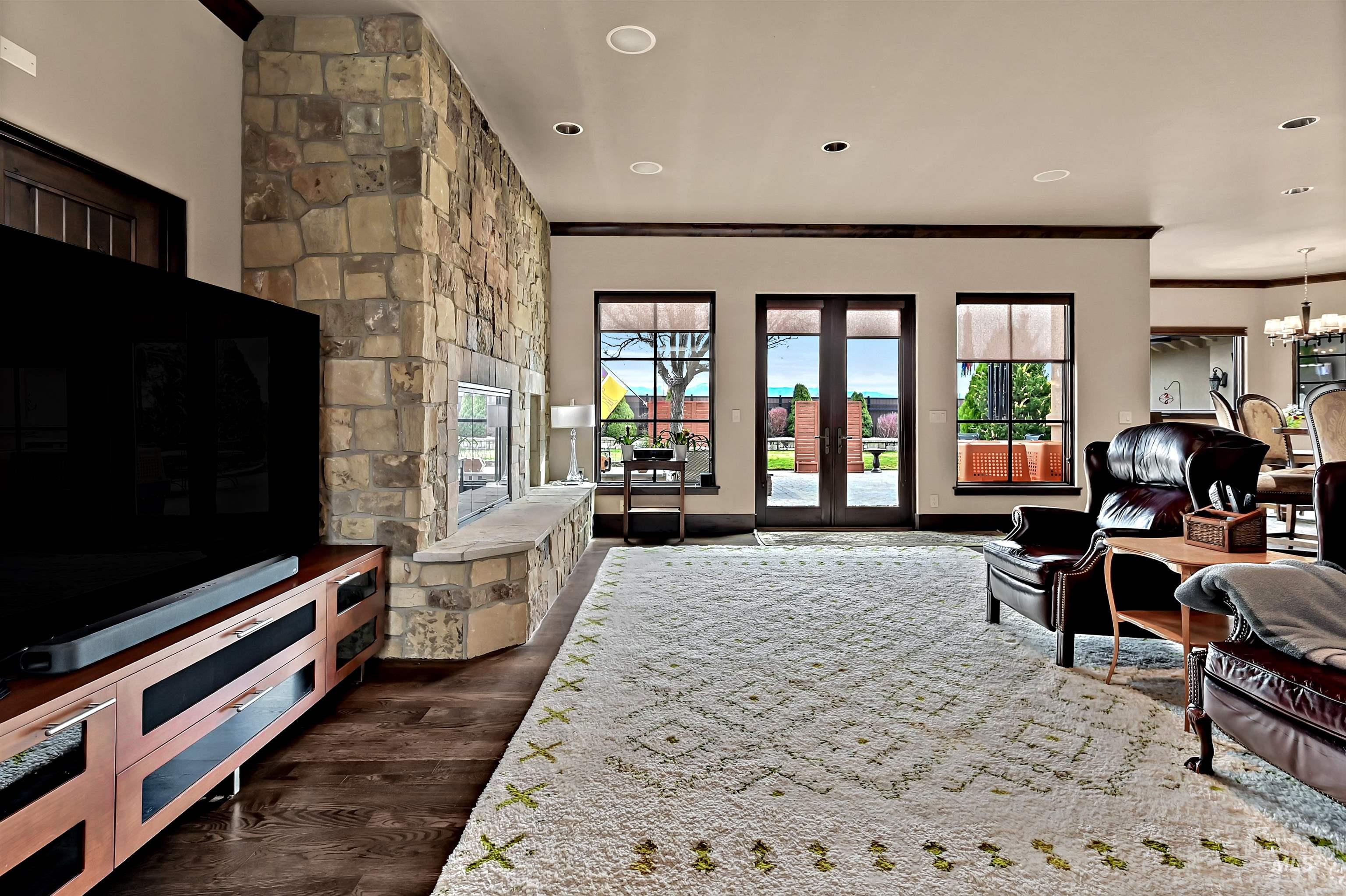 Living area featuring dark wood-style floors, ornamental molding, and a chandelier