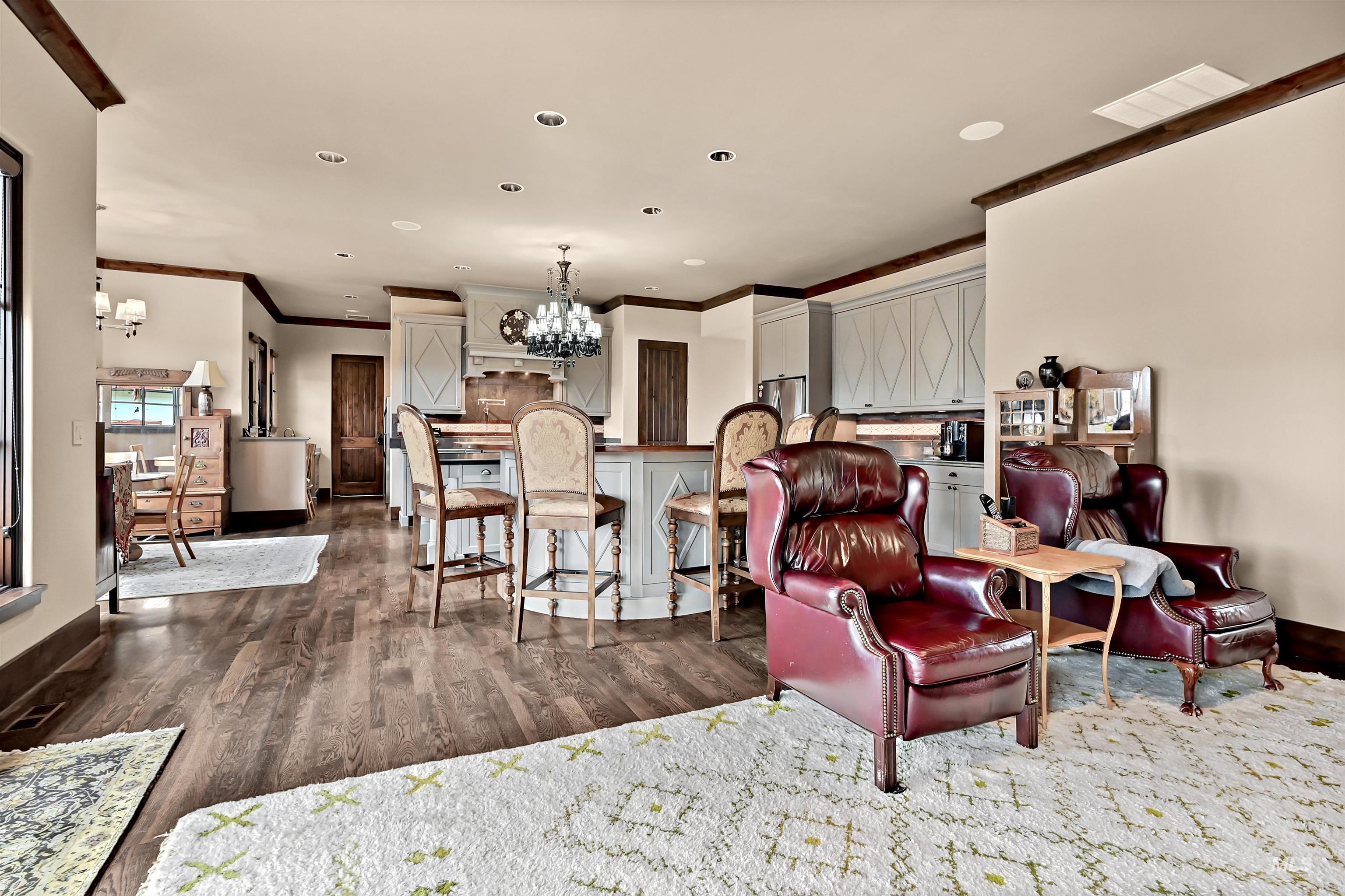 Living room featuring a chandelier, dark wood finished floors, and ornamental molding