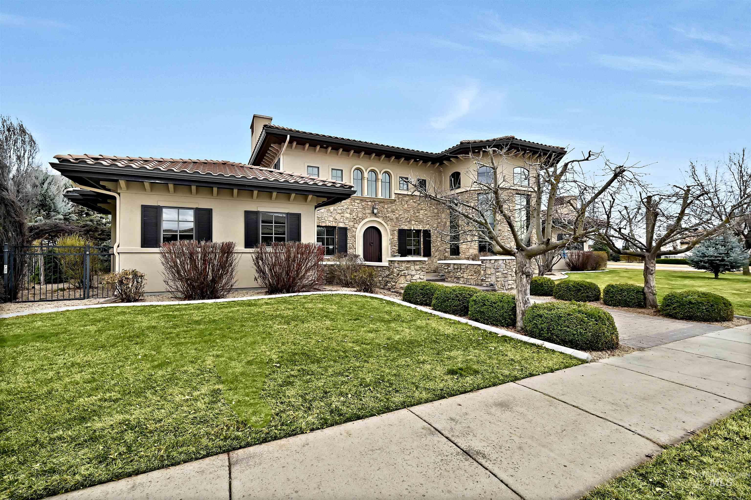 Mediterranean / italian-style home with stucco siding, stone siding, and a tiled roof