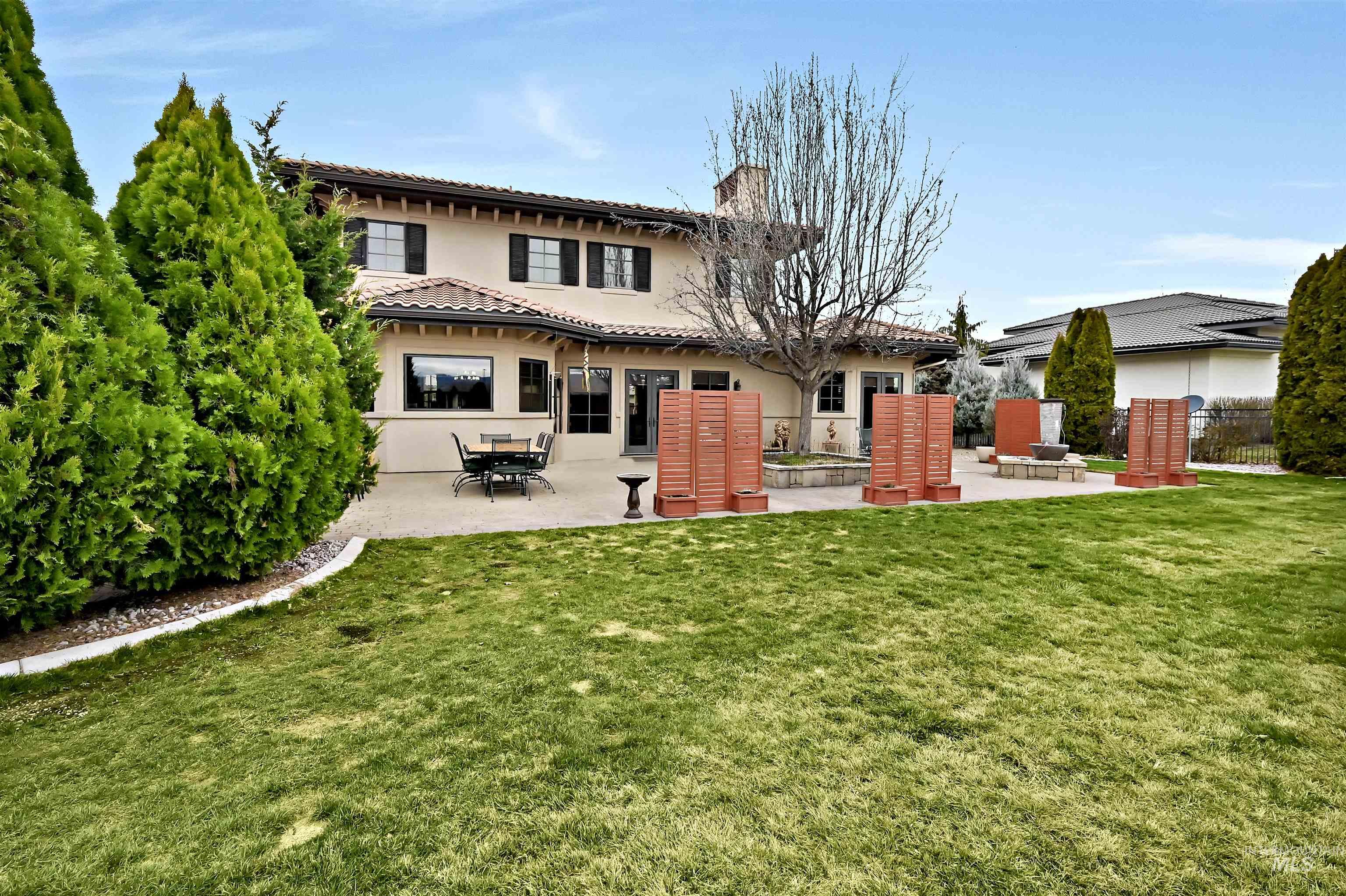 Back of house featuring a patio, a yard, stucco siding, and a tile roof