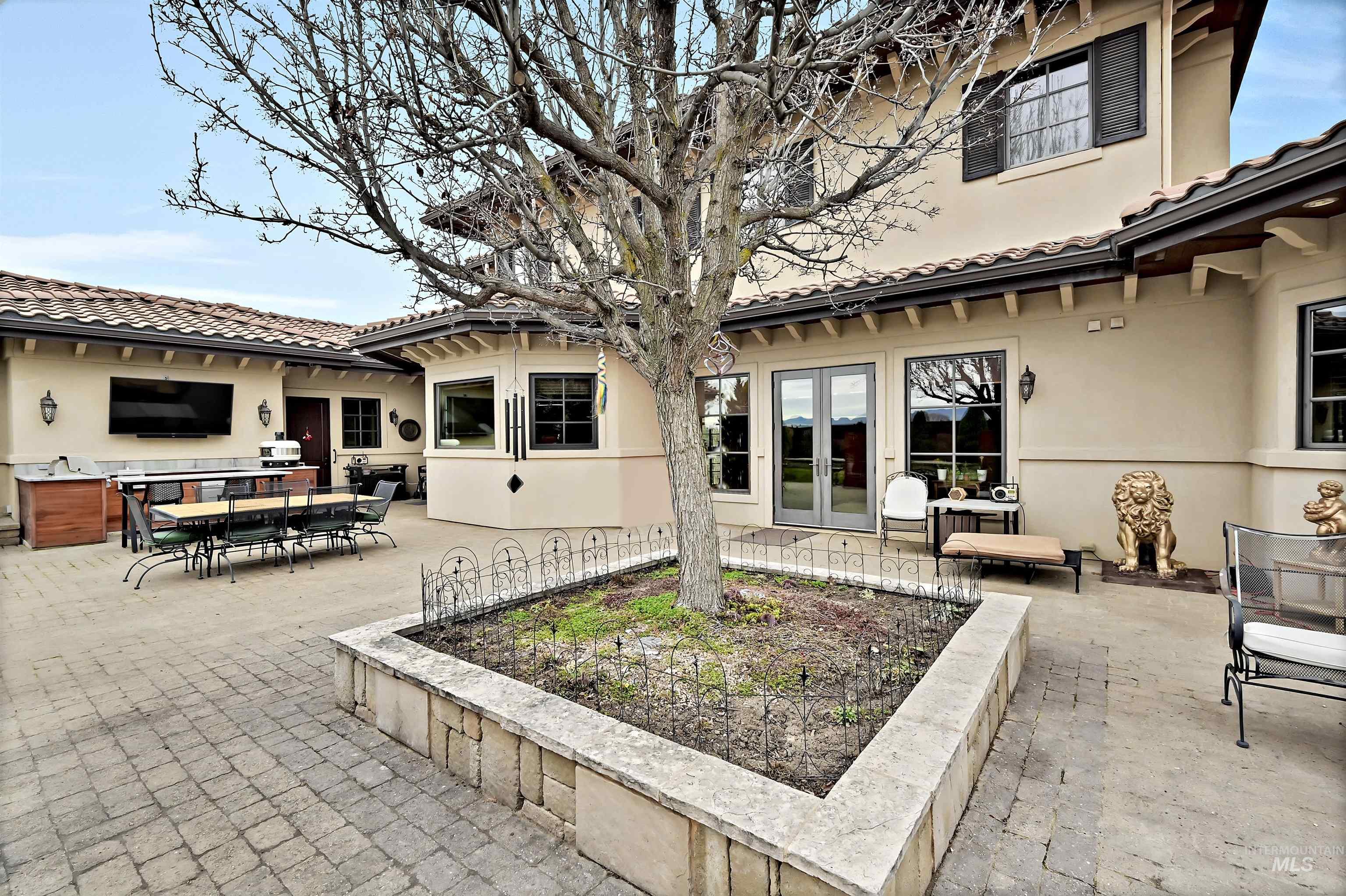 Rear view of house with stucco siding, outdoor dining area, a tile roof, and a patio area
