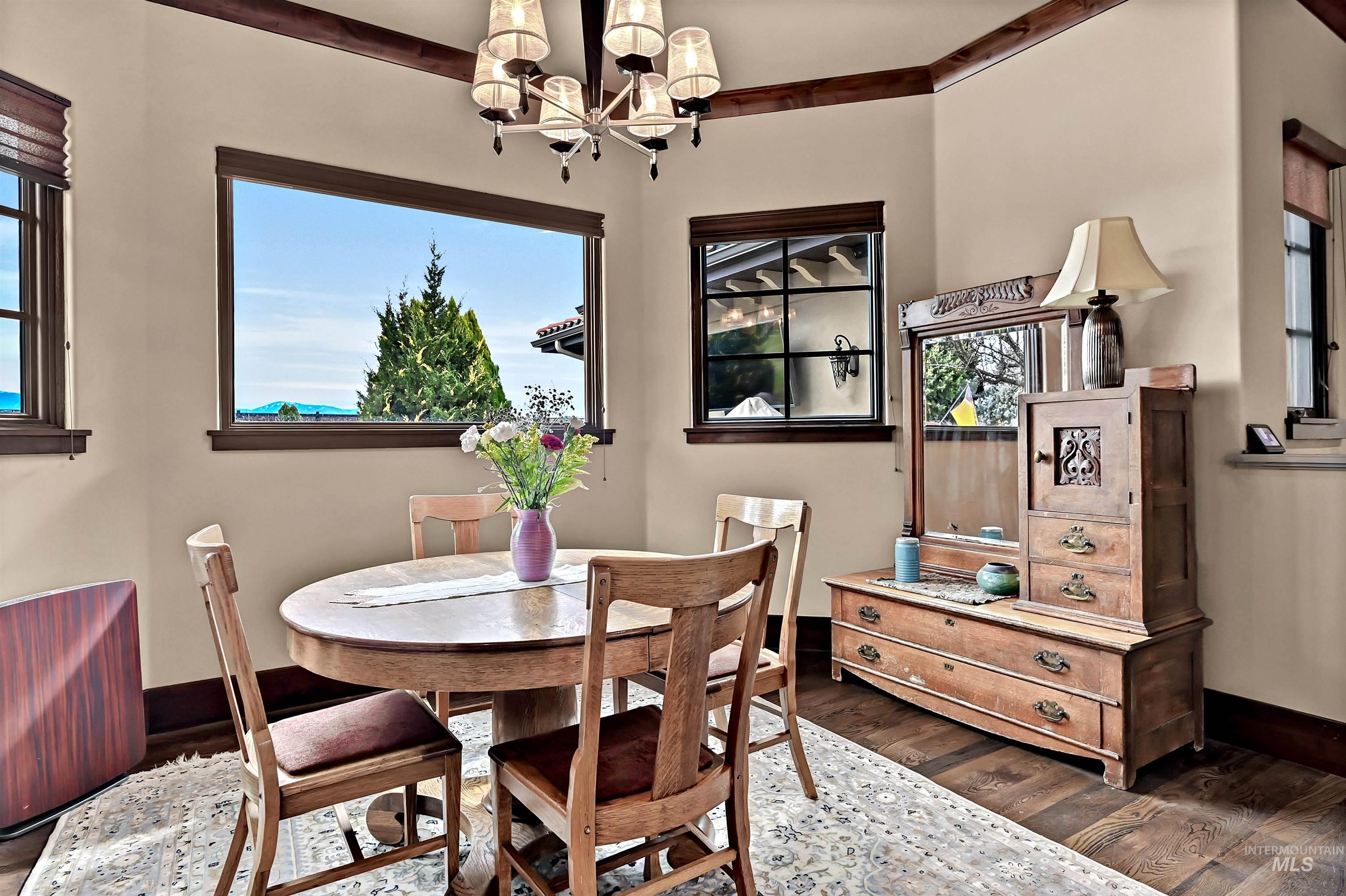 Dining space with decorative lighting and dark wood-style flooring