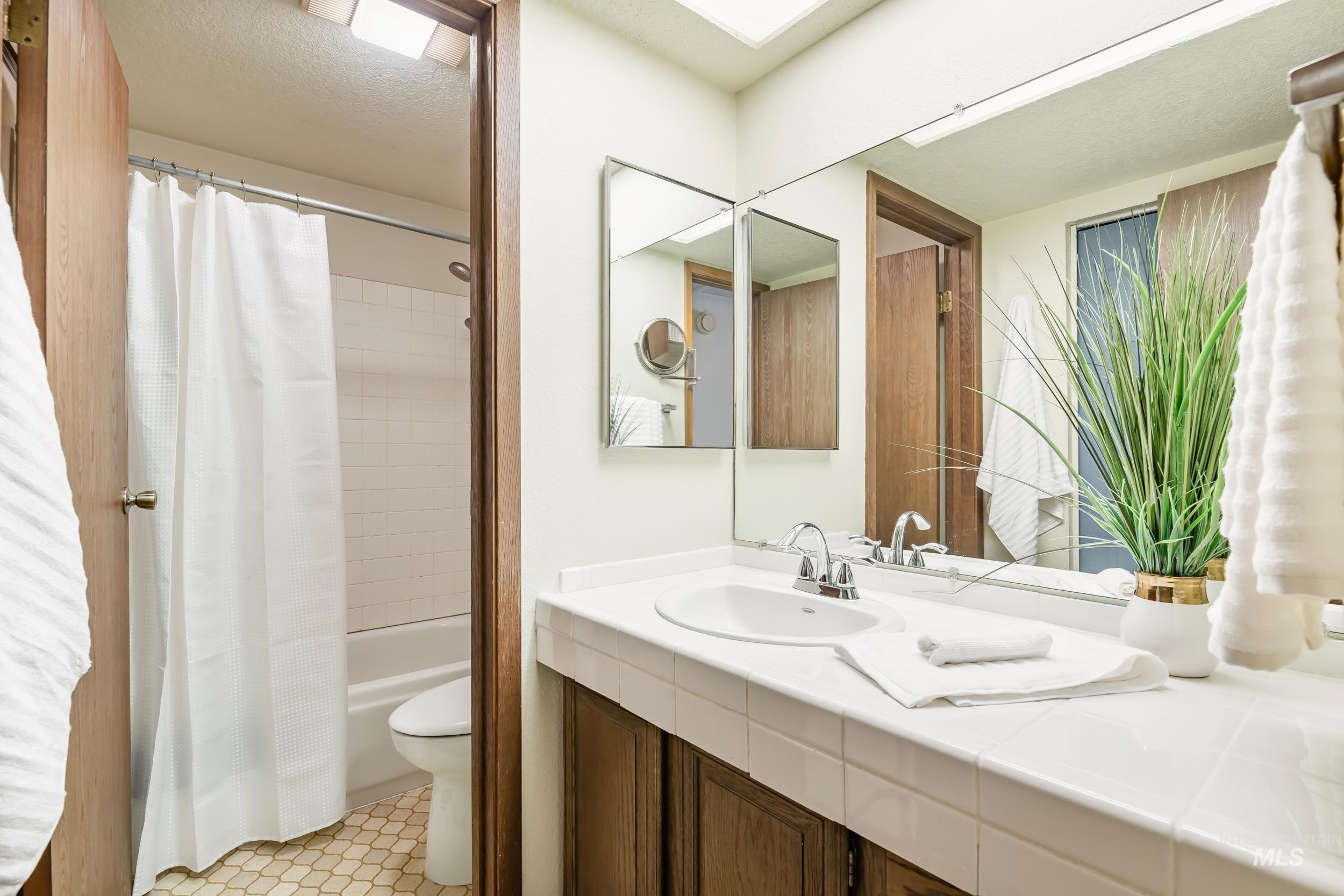 Full bath featuring vanity and shower / bath combo