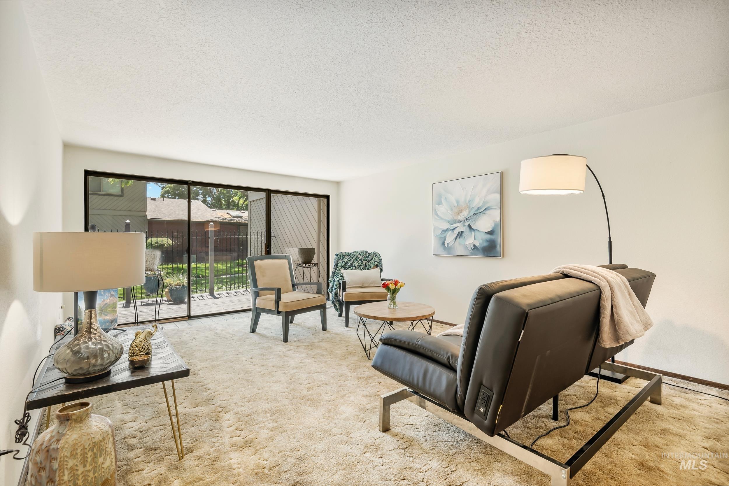 Living area featuring carpet flooring and a textured ceiling