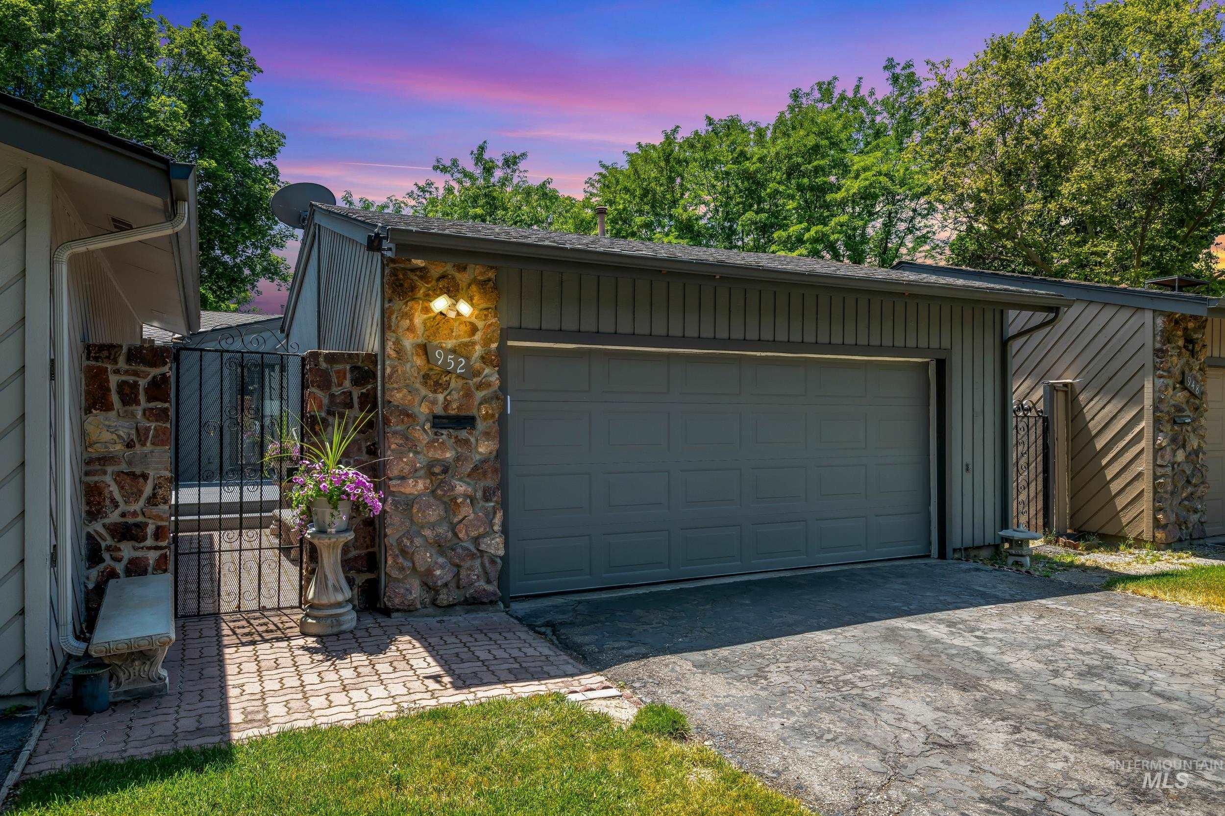 Garage featuring asphalt driveway and a gate