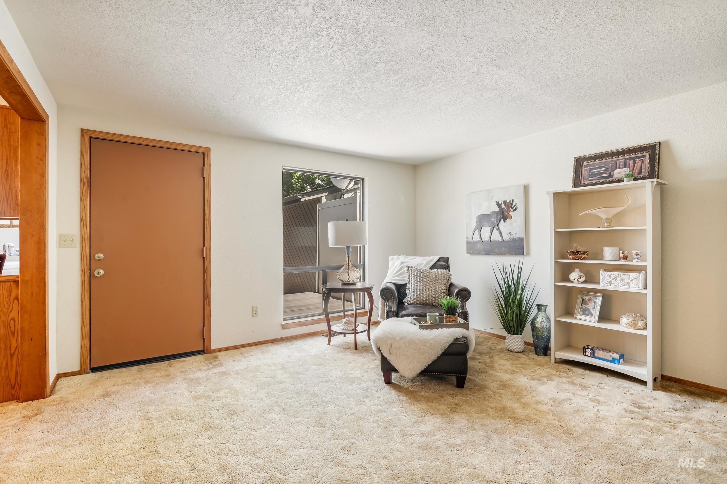 Sitting room featuring a textured ceiling and carpet