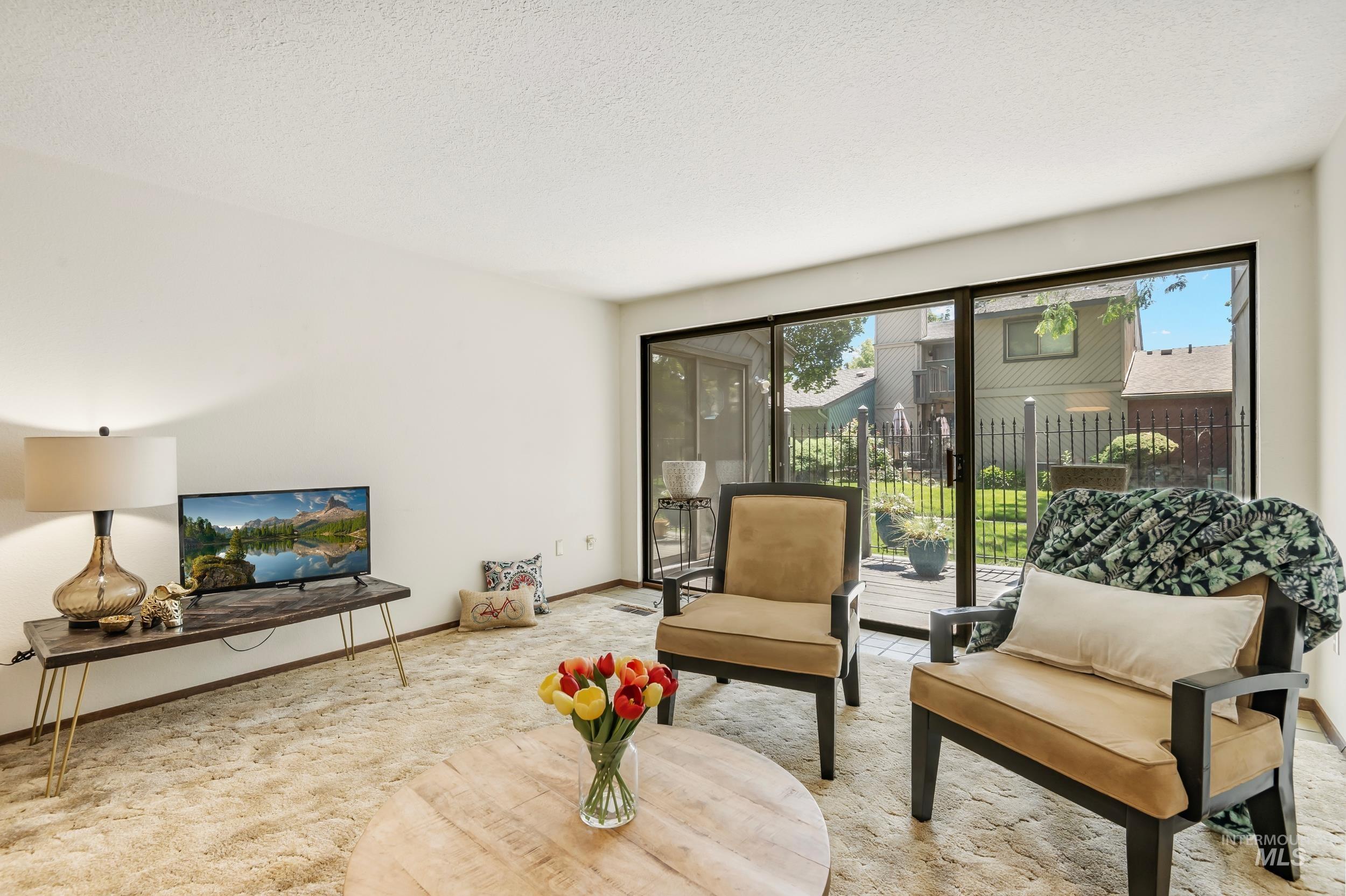 Living area featuring carpet and a textured ceiling
