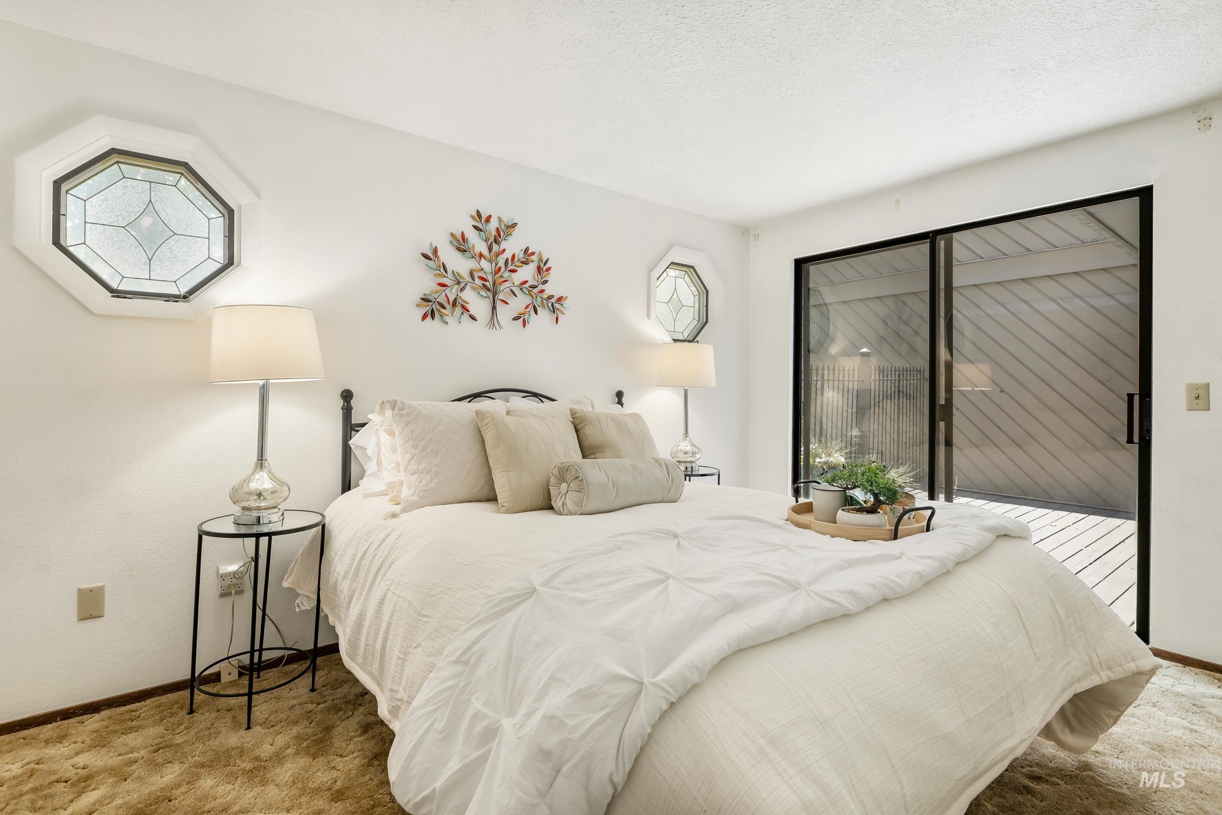 Bedroom with carpet and access to outside