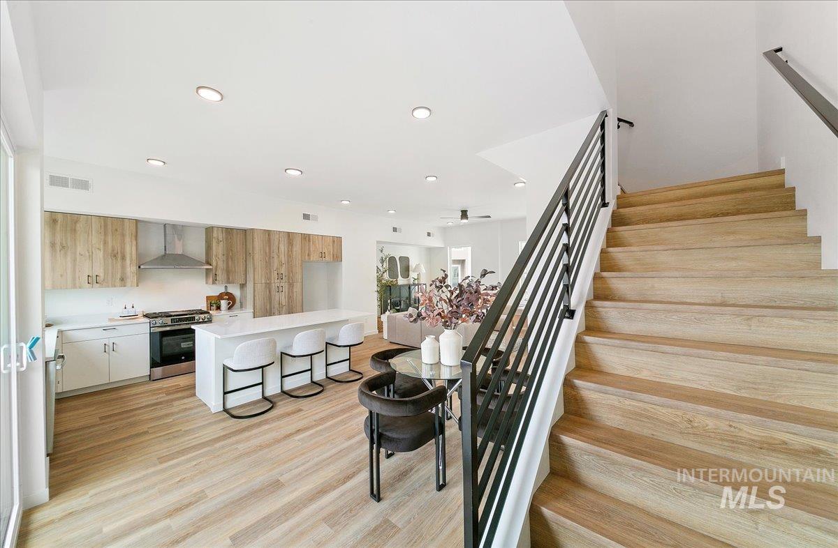 Stairway featuring wood finished floors and recessed lighting