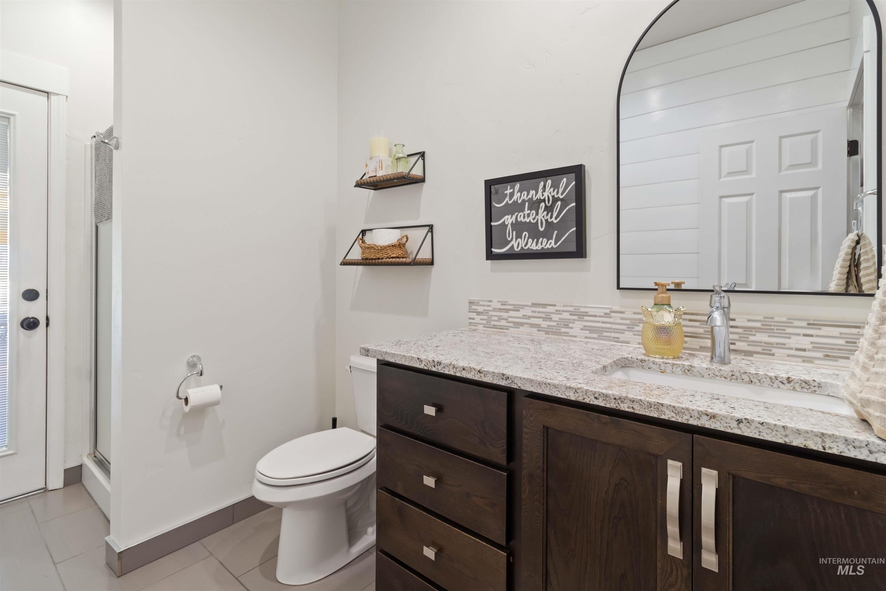 Direct door to pool area, tile floor, shiplap wall with hooks & newer vanity with granite counter