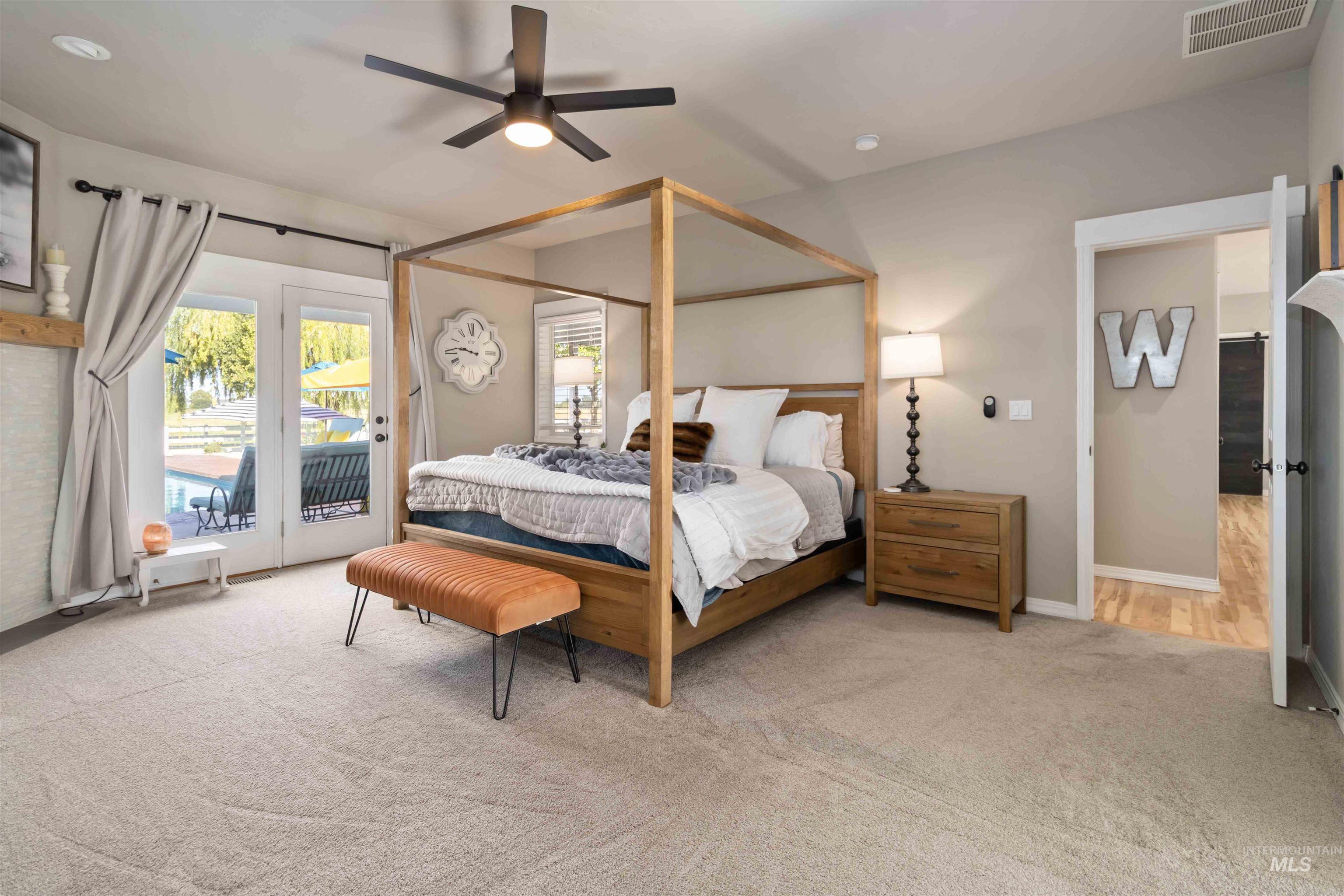 Bedroom featuring light carpet, ceiling fan, and access to outside