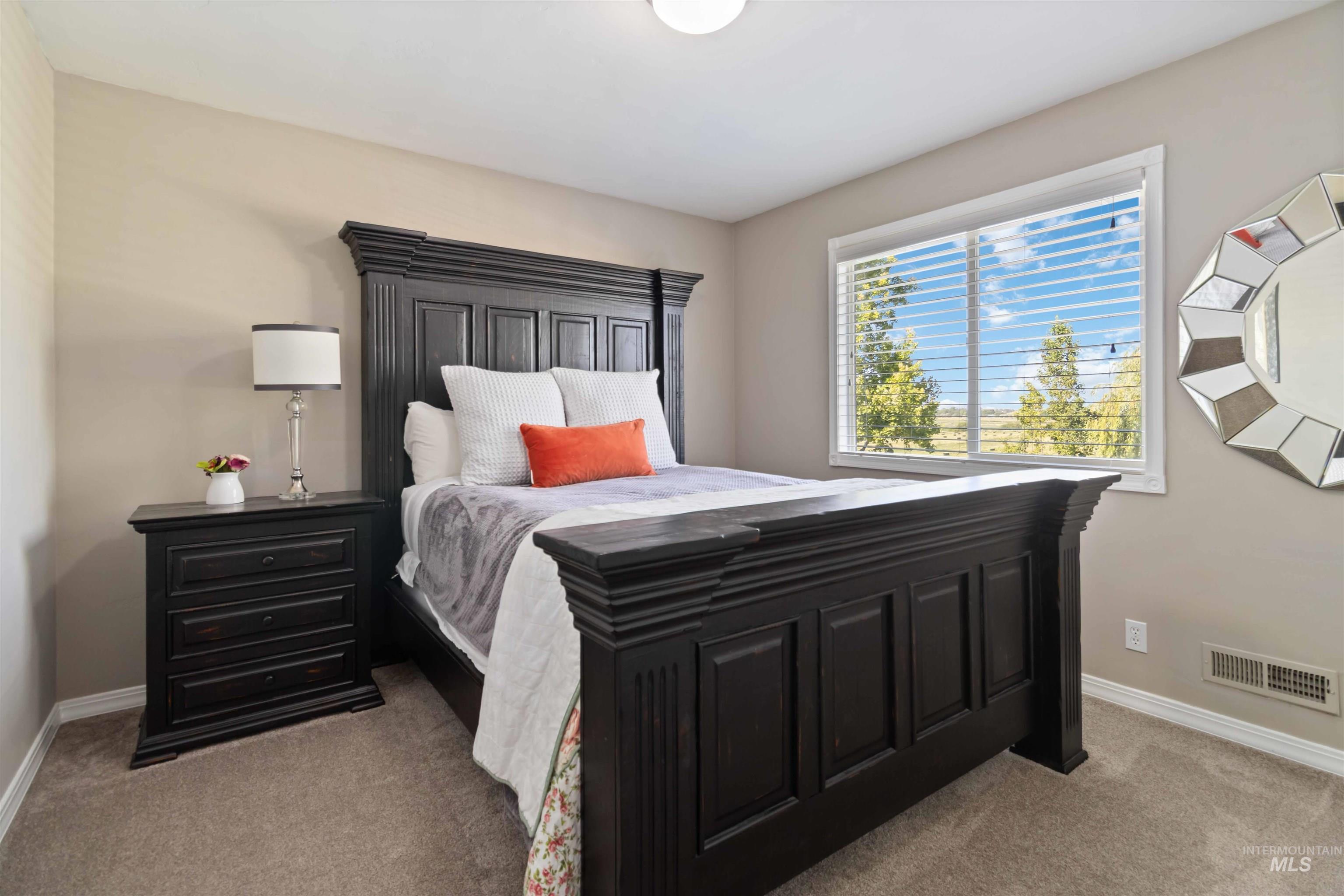 Bedroom with baseboards and light colored carpet