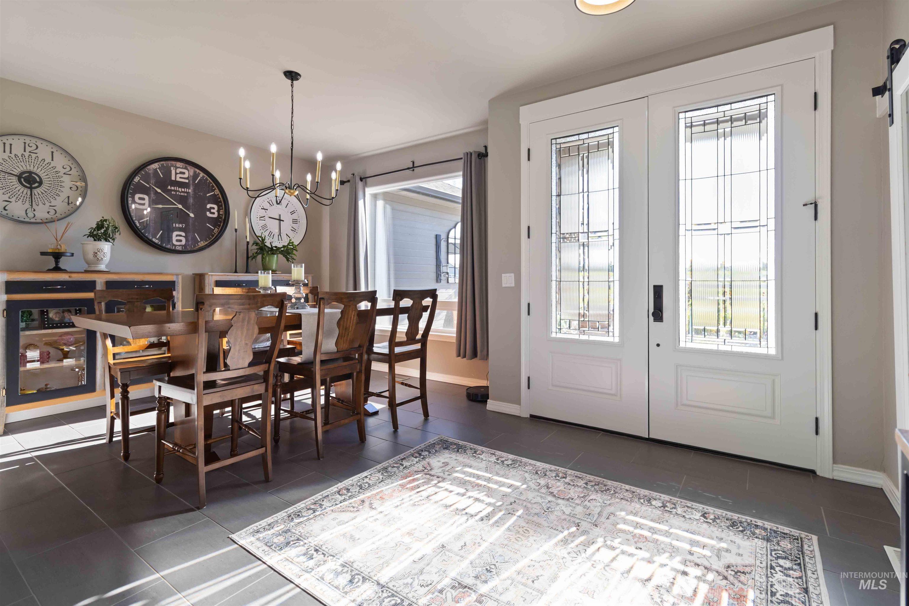 Dining area with healthy amount of natural light, a chandelier, french doors, and dark tile patterned flooring