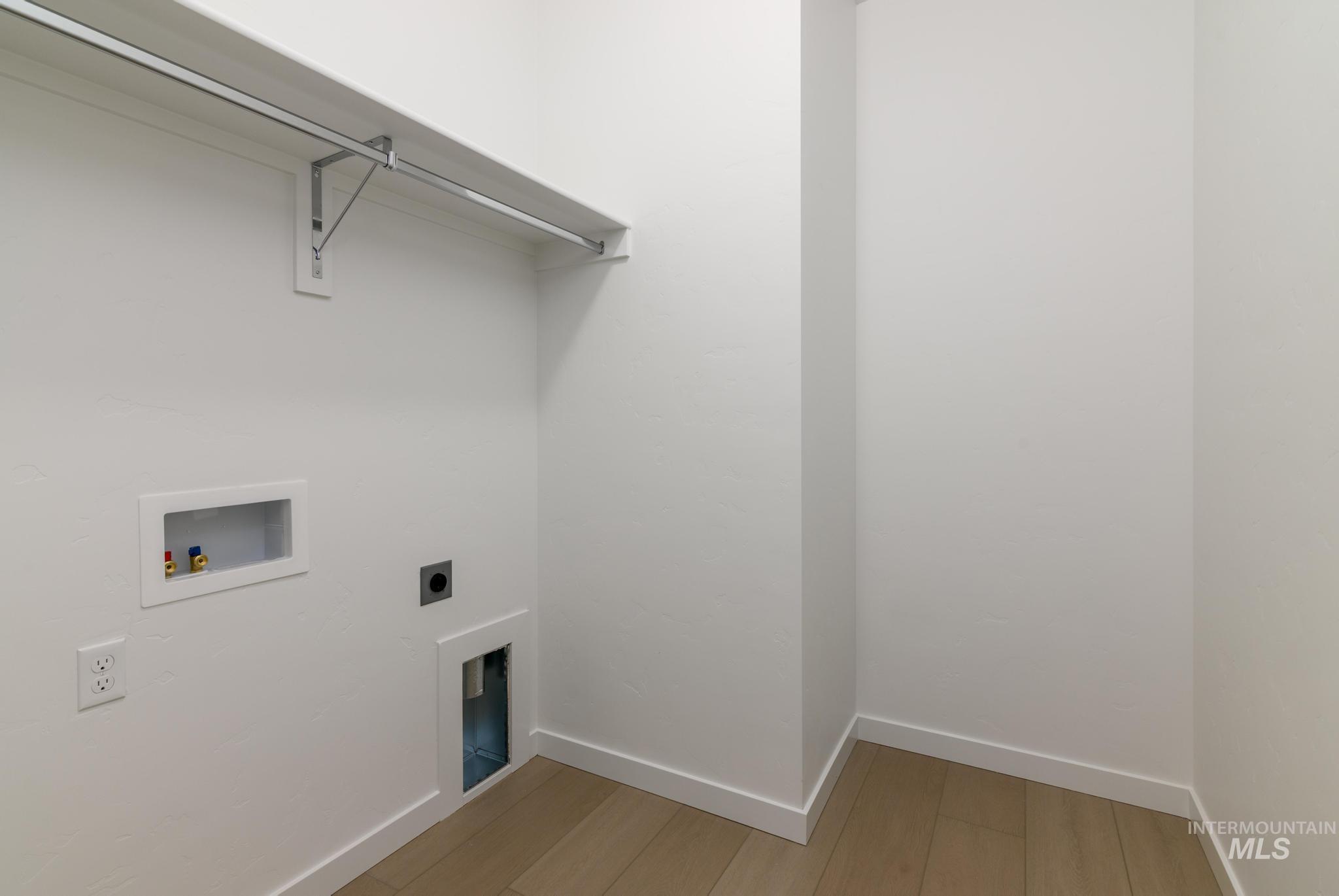 Laundry room featuring hookup for an electric dryer, washer hookup, and light wood finished floors