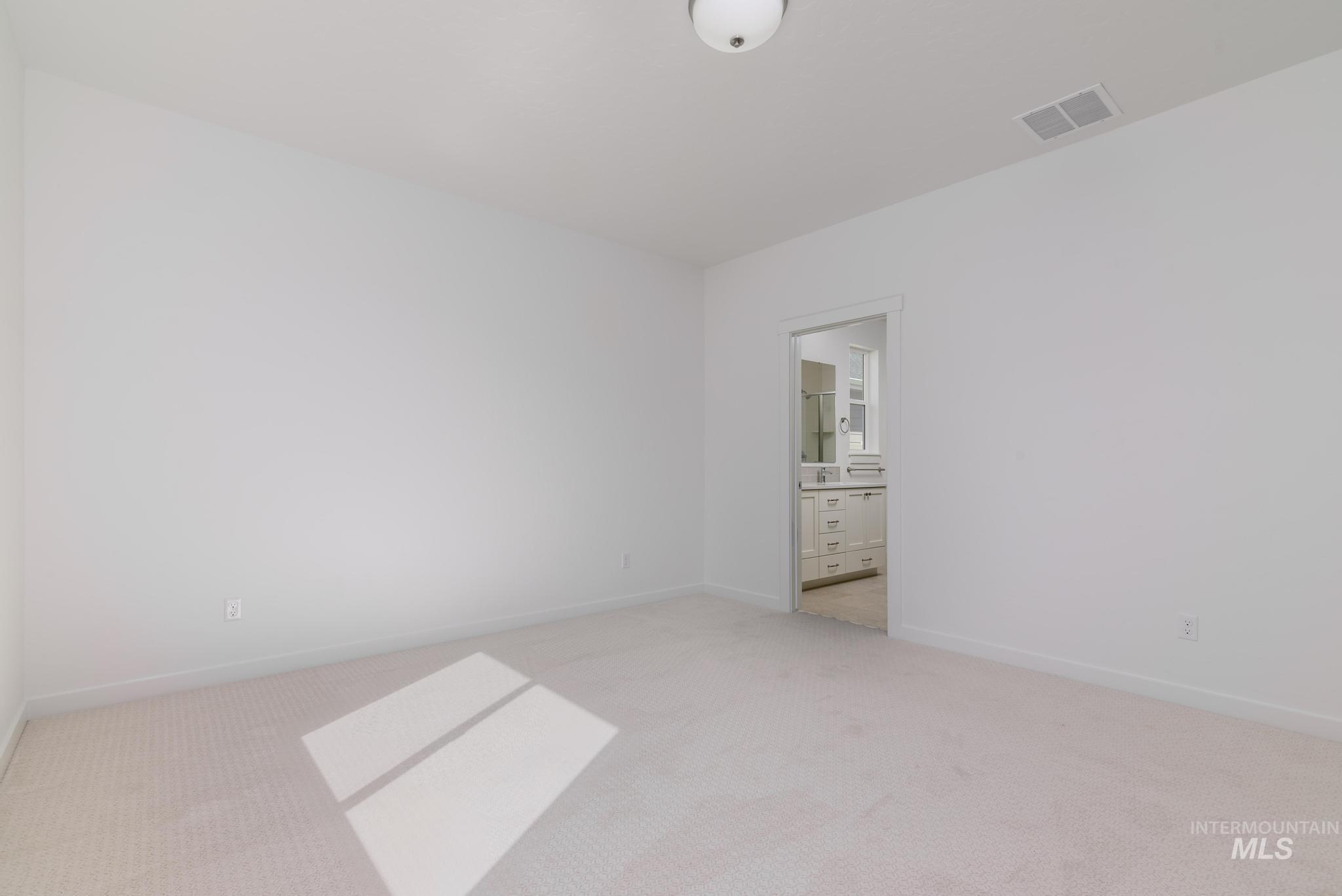 Empty room featuring light colored carpet