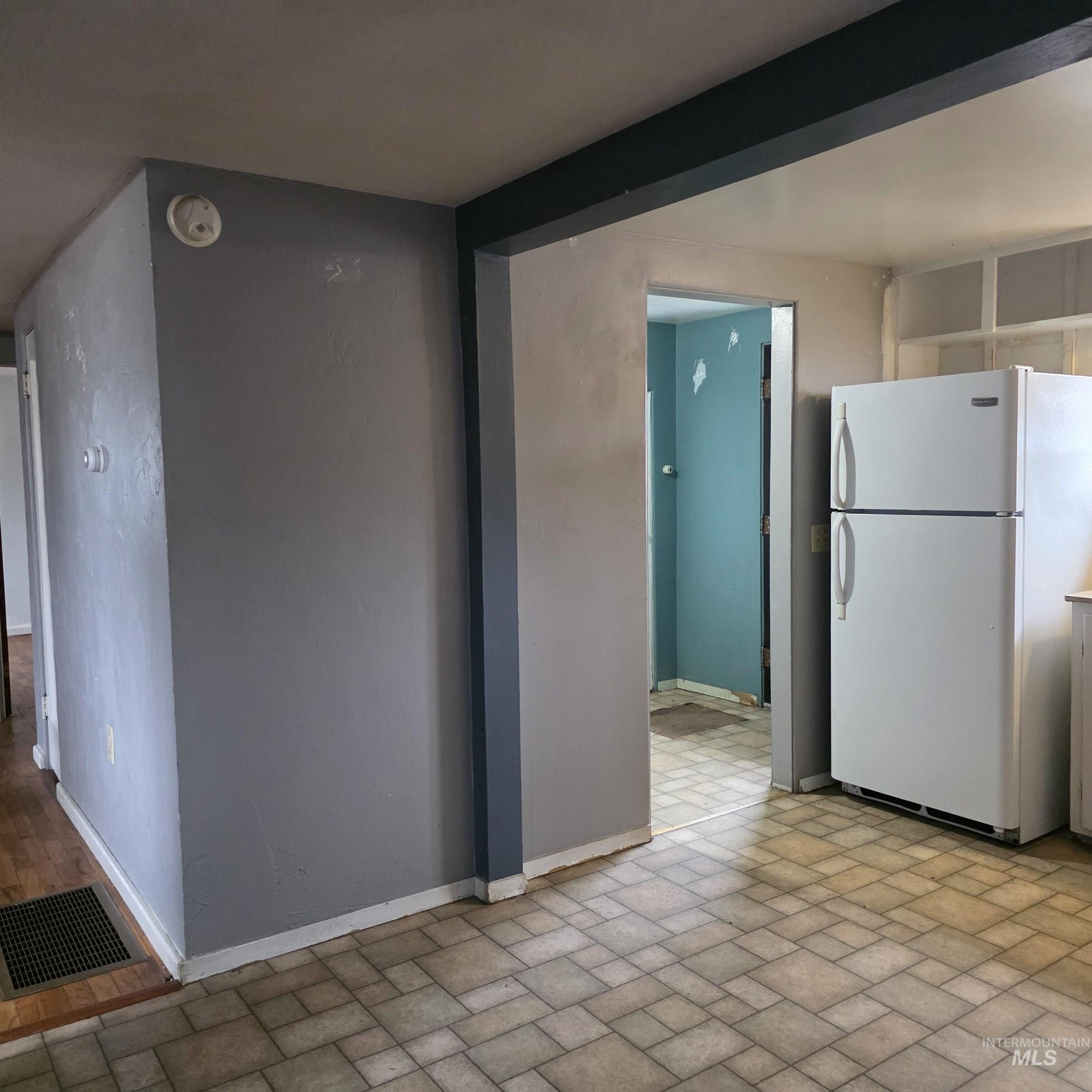 Kitchen with freestanding refrigerator and baseboards