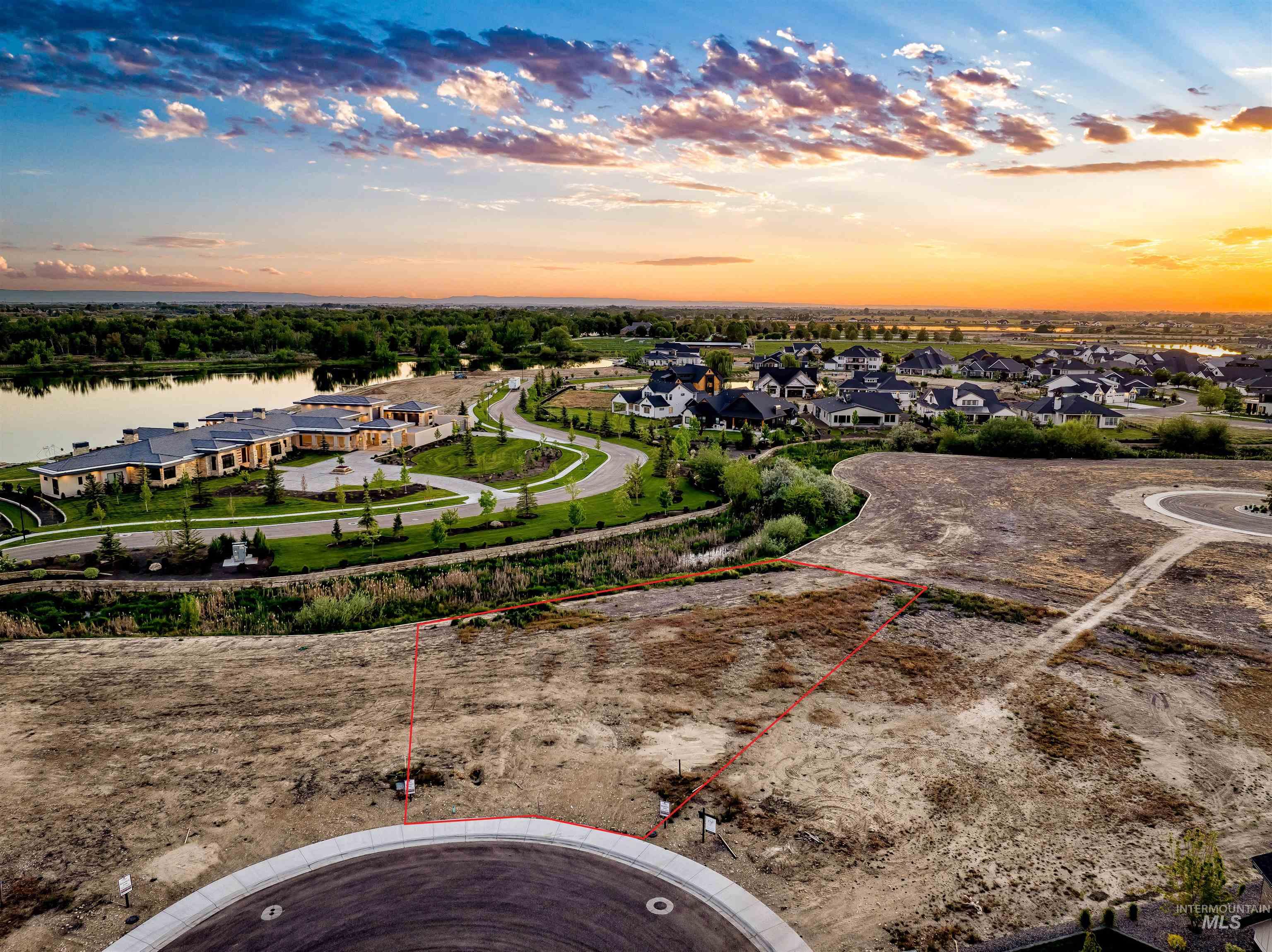 Aerial view at dusk of a residential view, property parcel outlined, and a water view
