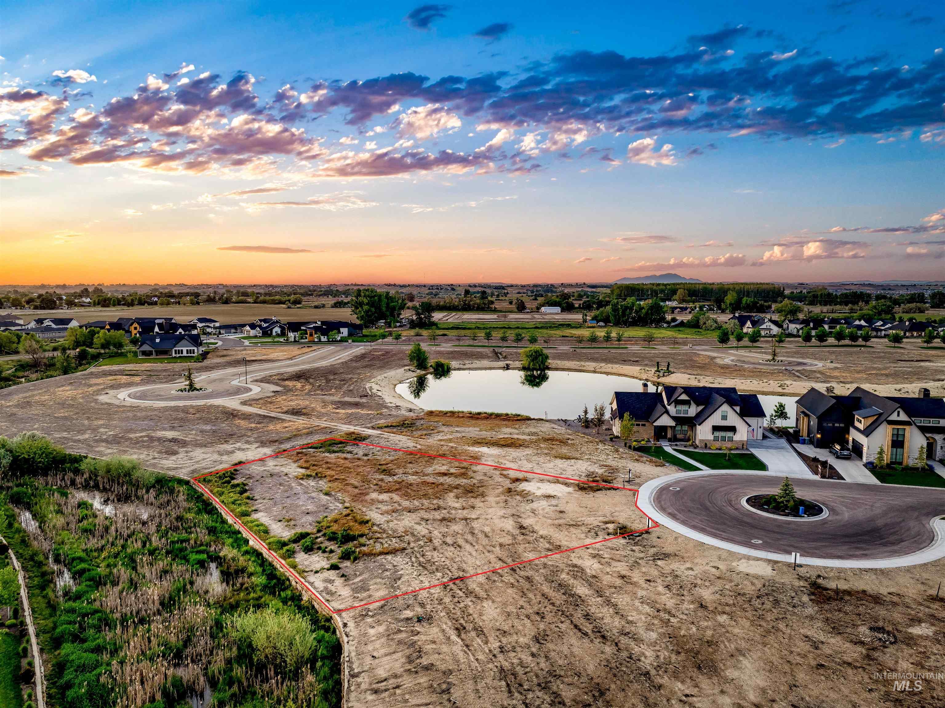 Aerial view at dusk of a water view, property boundaries highlighted, and a residential view