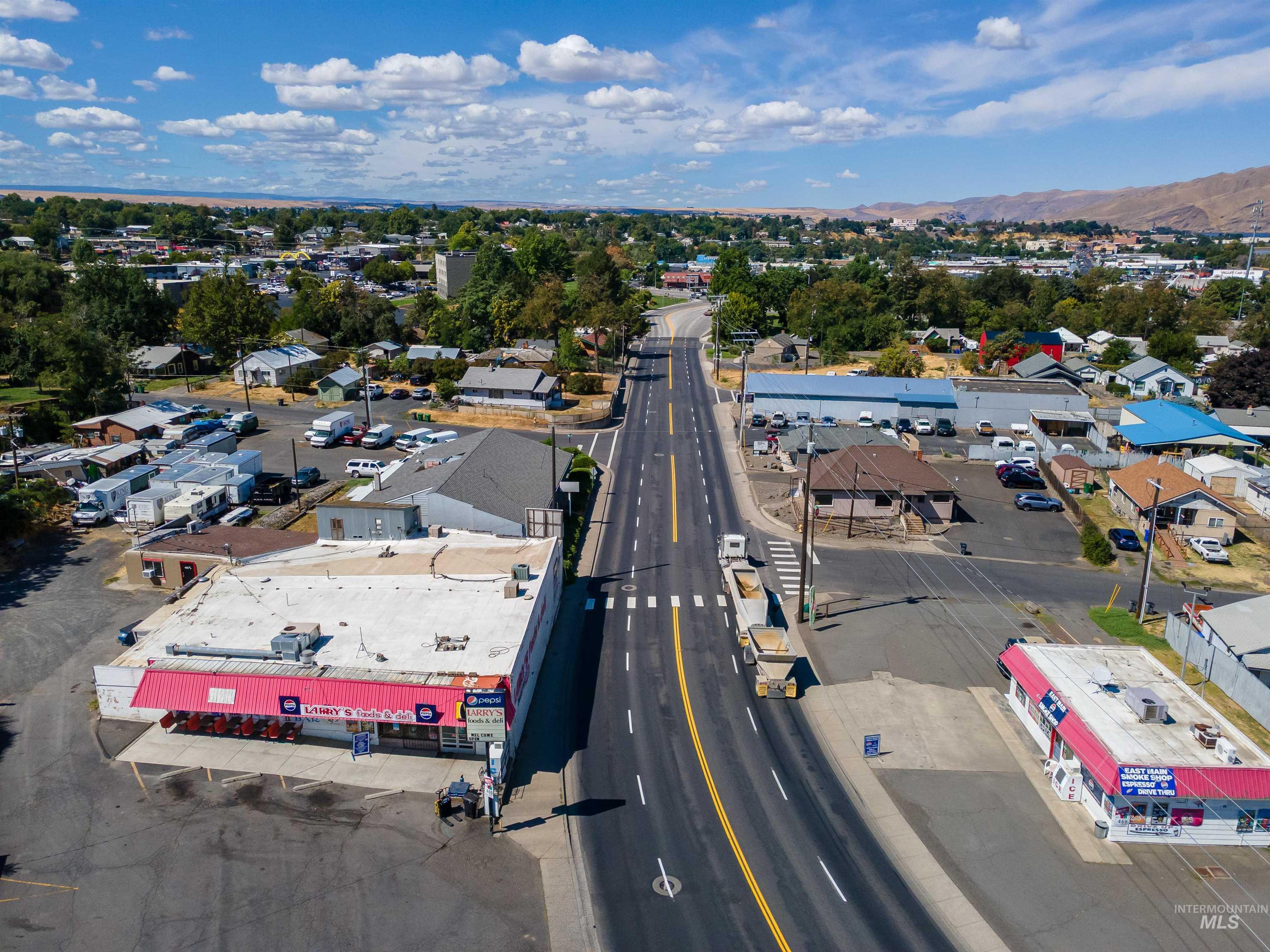 Aerial view of property and surrounding area featuring a commercial area