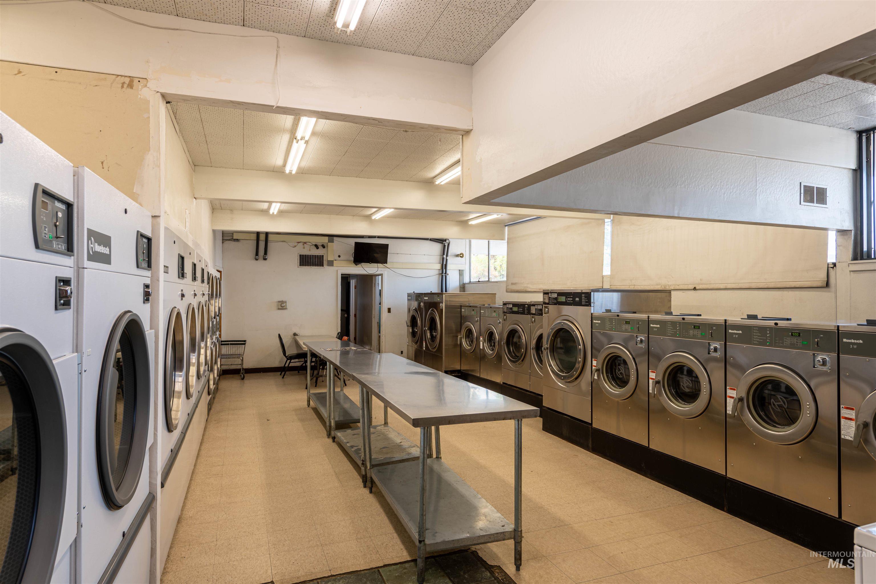 Shared laundry room with washing machine and clothes dryer