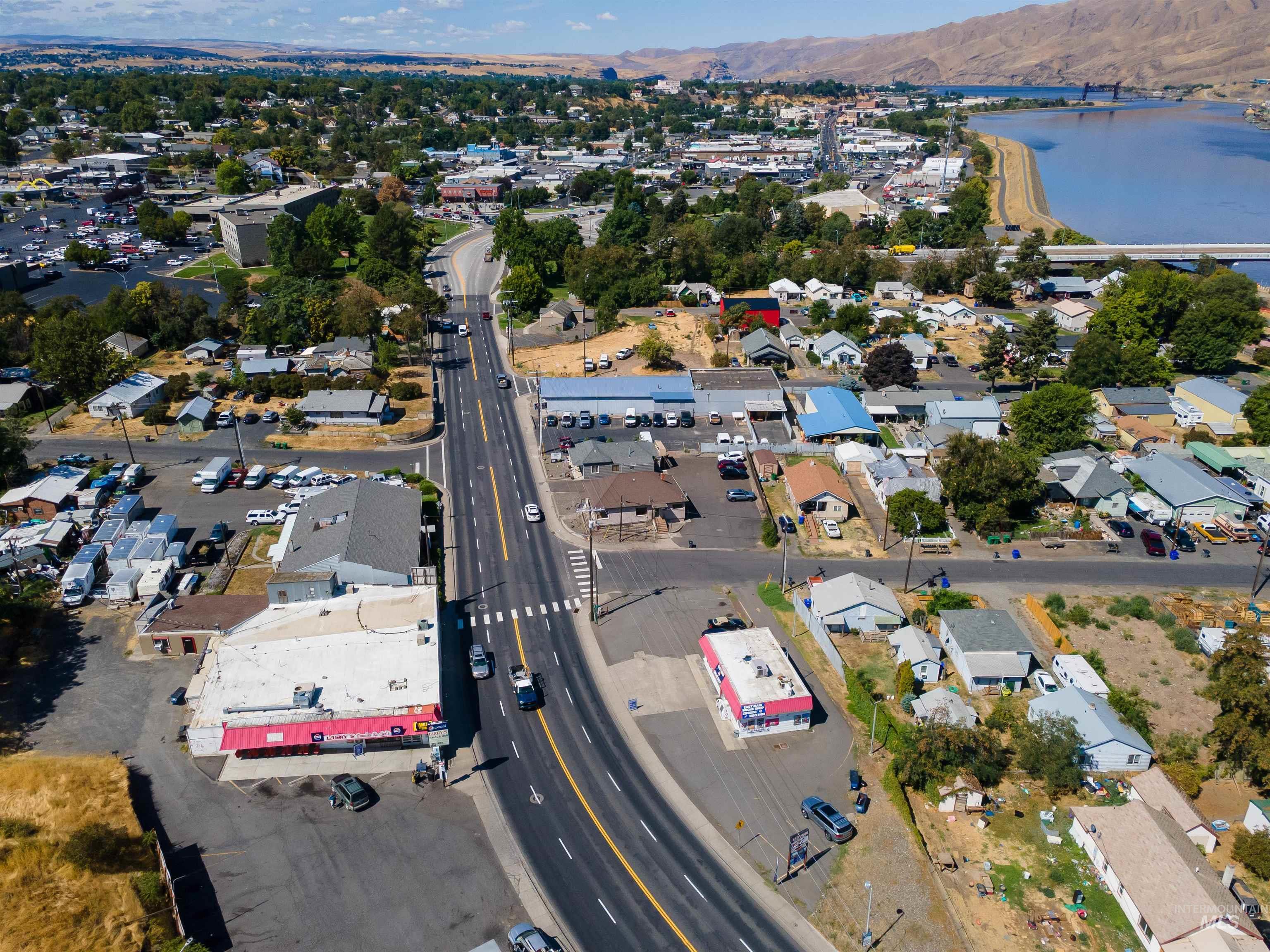 Aerial view of property's location featuring a water and mountain view and nearby suburban area