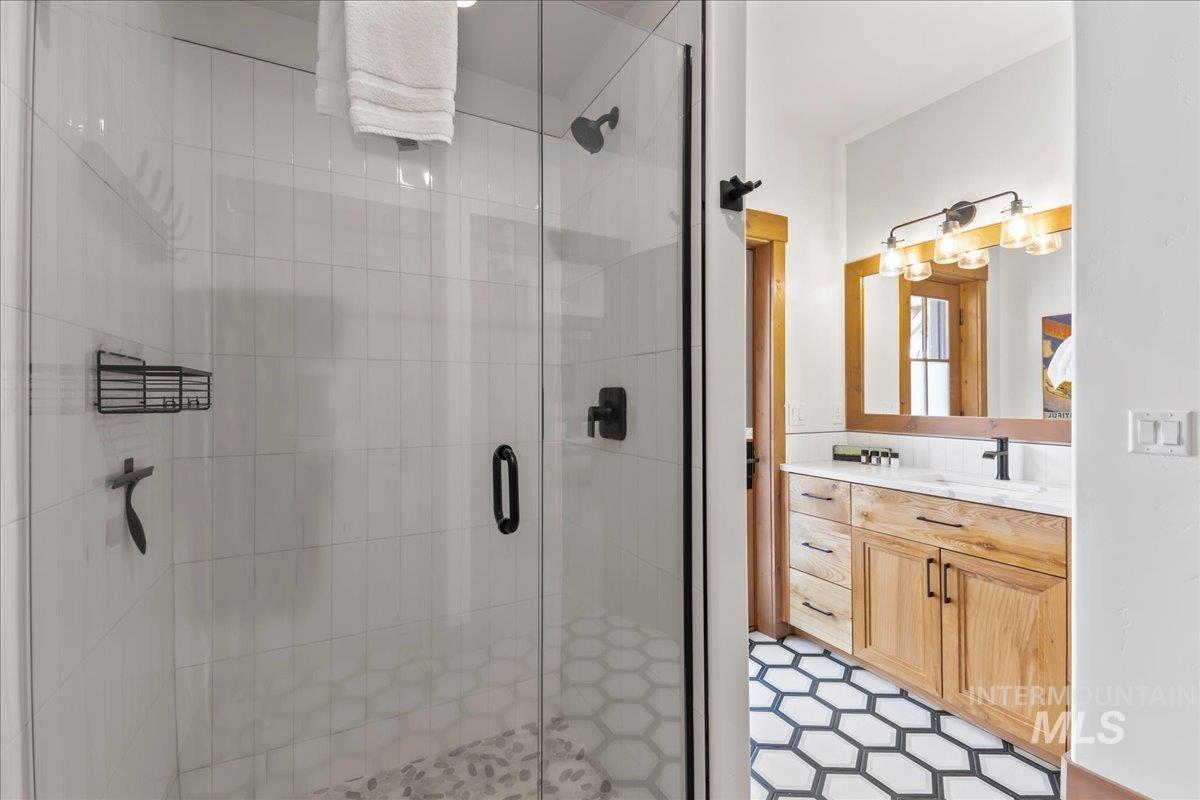 Bathroom with vanity, a shower stall, and light tile patterned floors