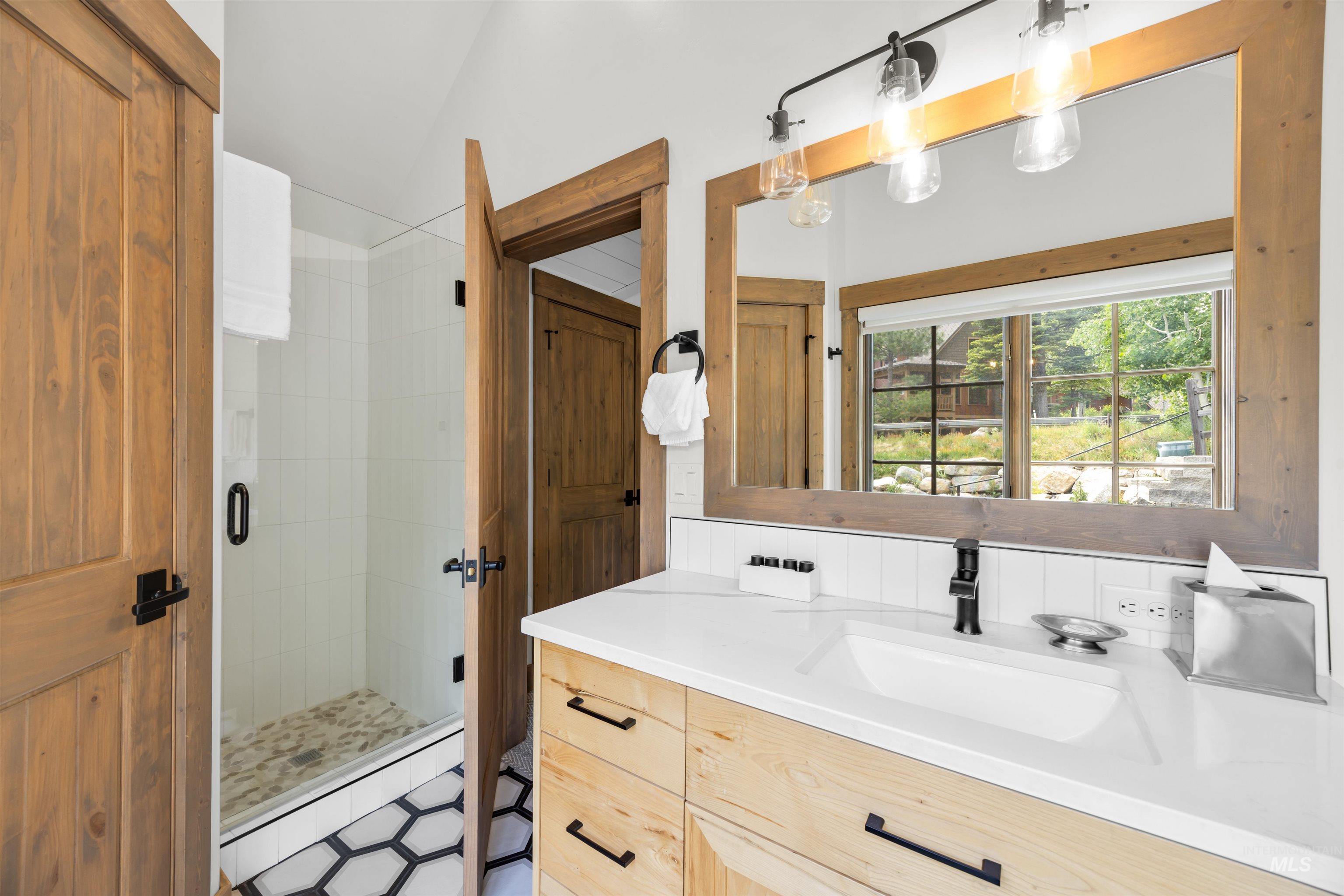 Bathroom featuring a light wood-finish vanity with a white countertop and integrated sink