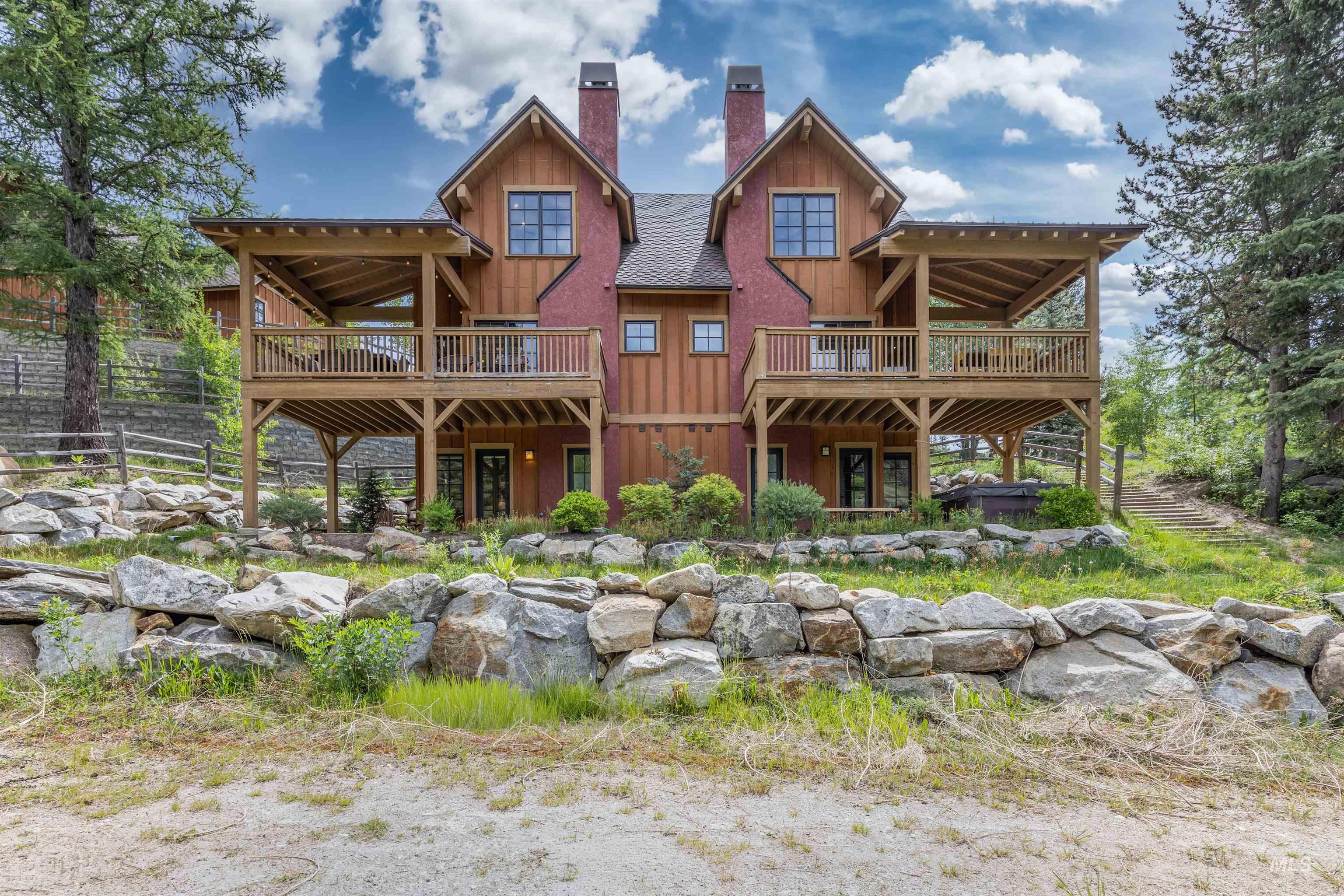Rustic-inspired architecture featuring a warm wood siding, red stucco, and multiple covered decks