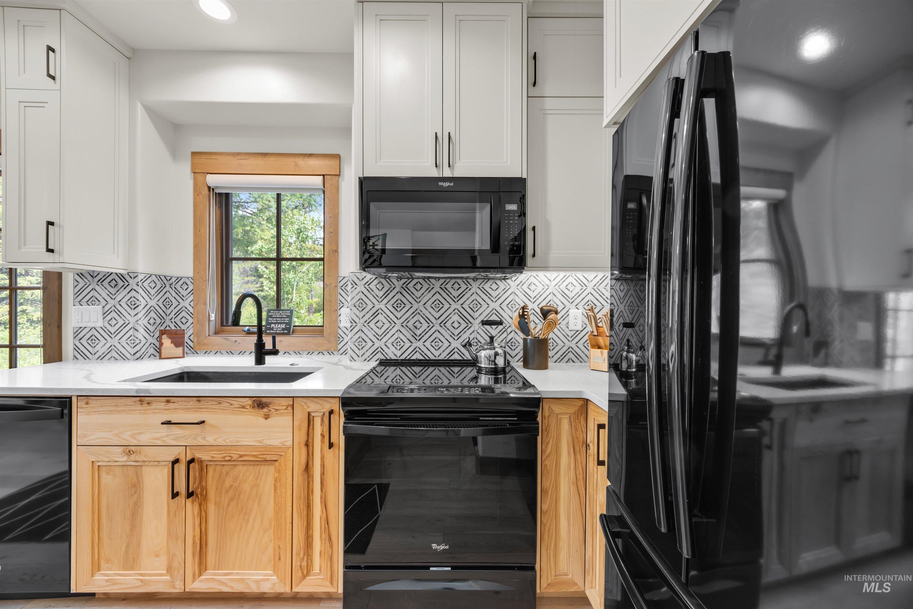 Modern kitchen featuring white upper cabinetry and natural wood-finish lower cabinetry