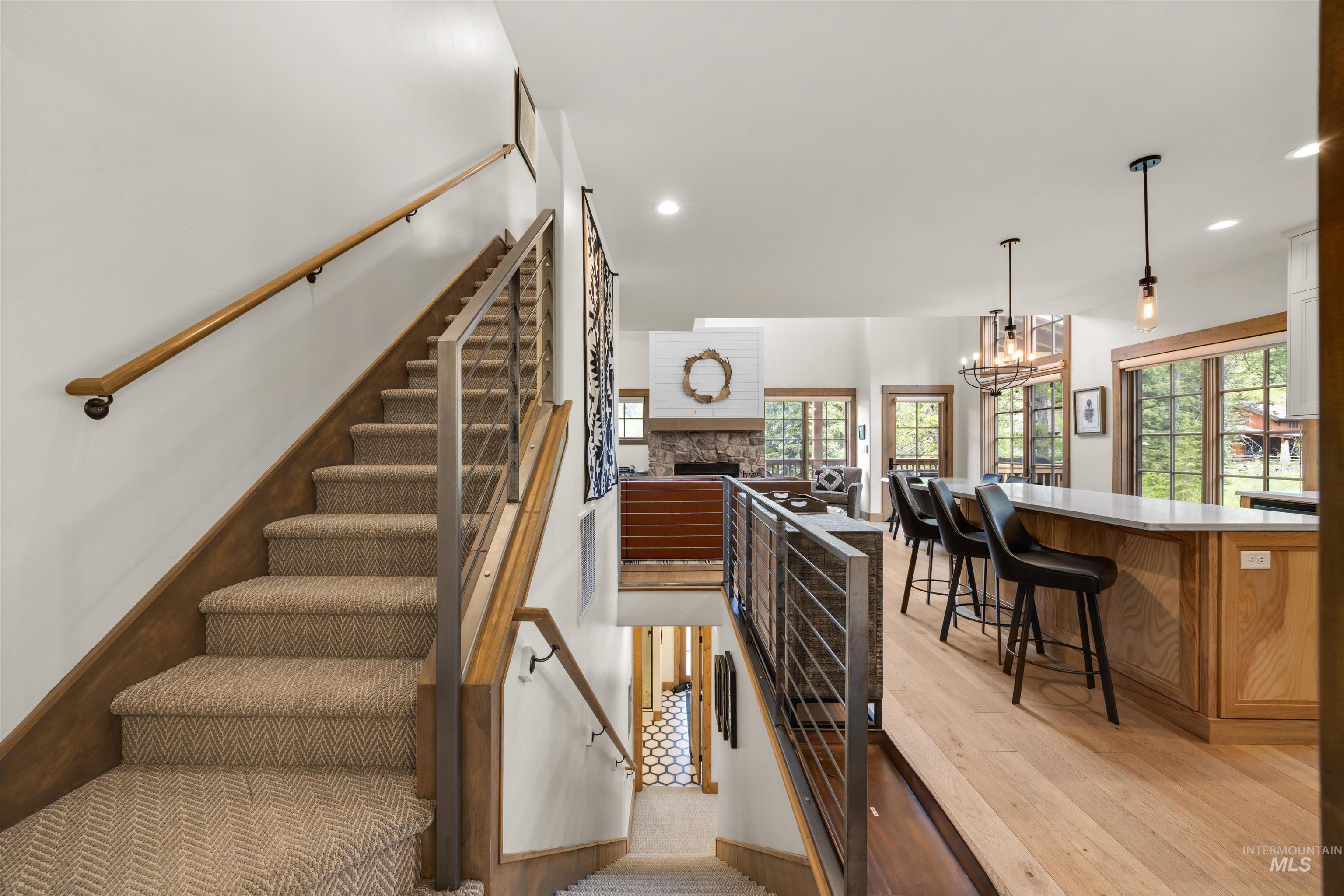 Staircase featuring carpeted treads, wood-finish risers, and a contemporary cable railing system