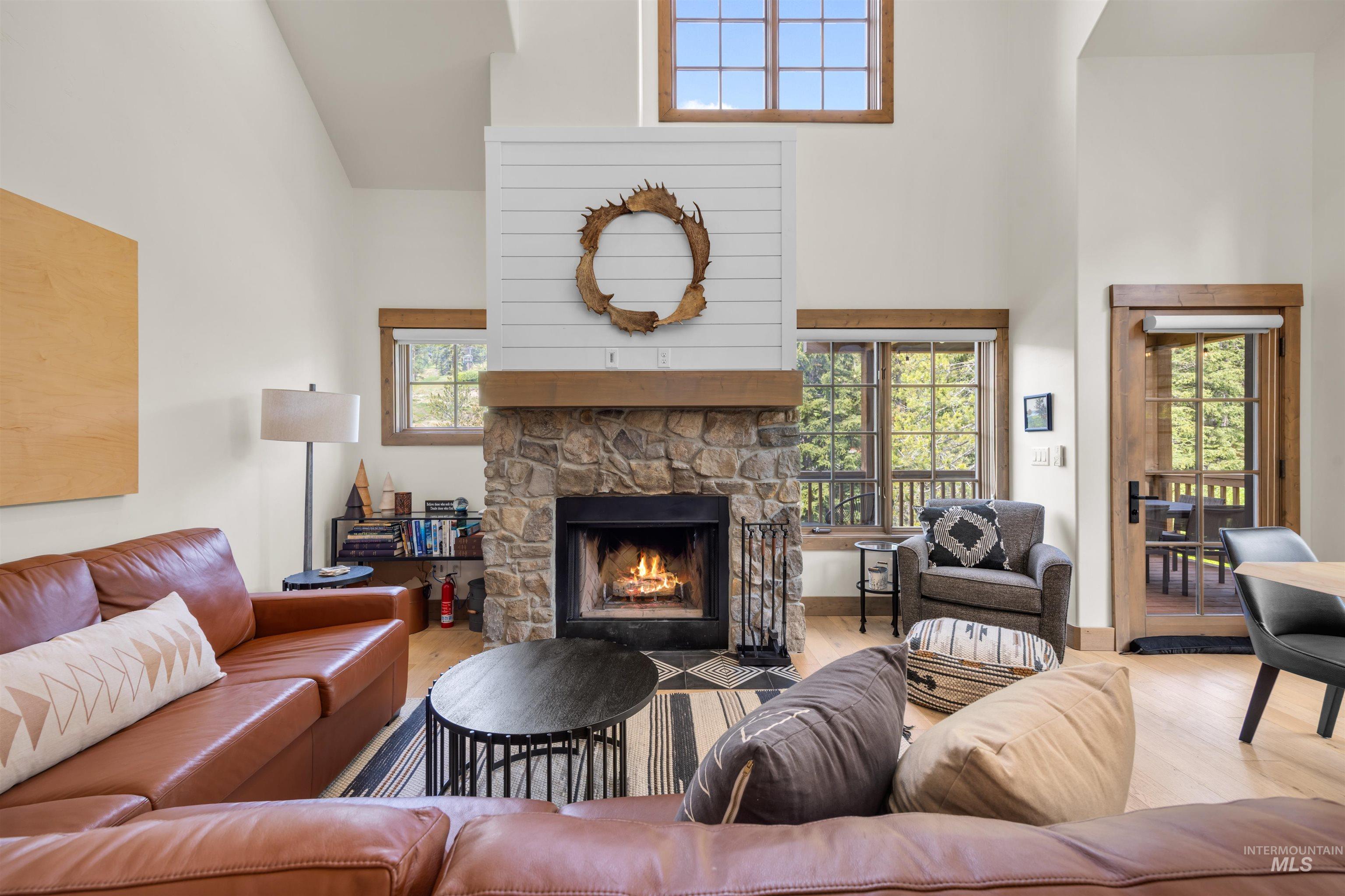 Vaulted ceilings complementing a stacked stone fireplace with a substantial wood mantel