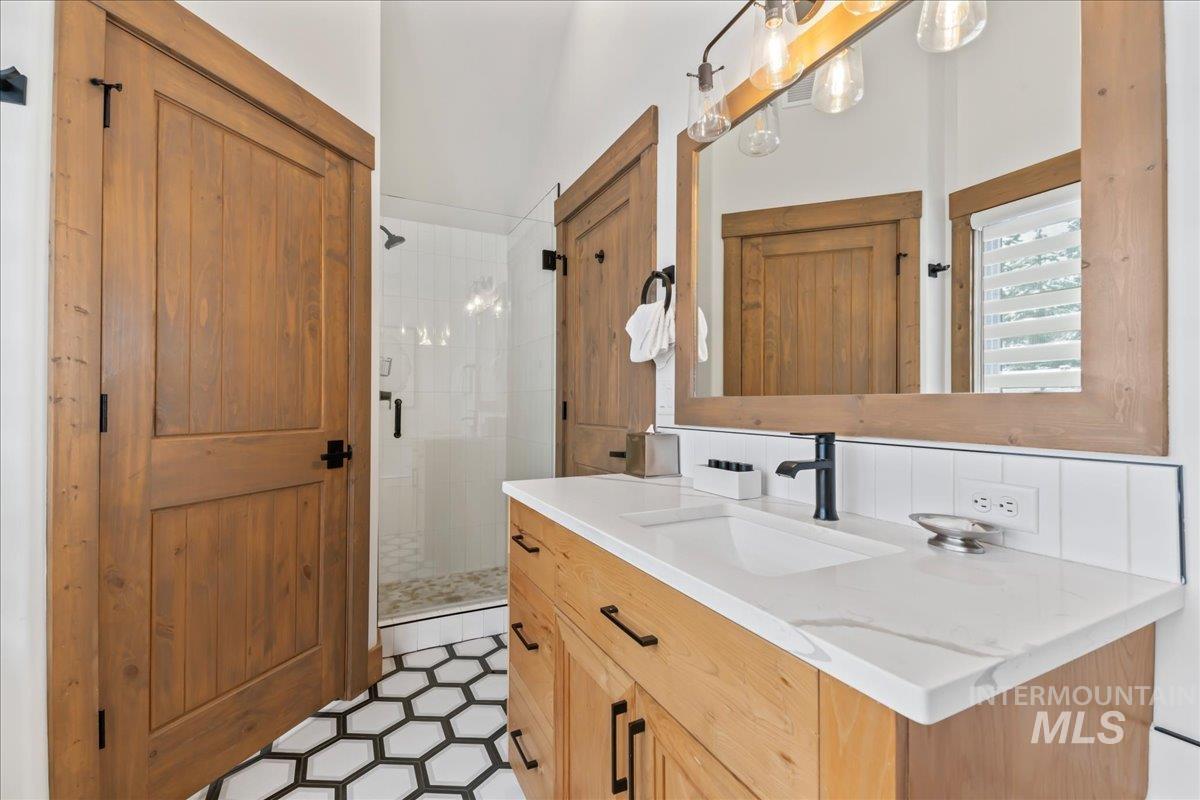 Bathroom featuring vanity, a stall shower, and light tile patterned floors