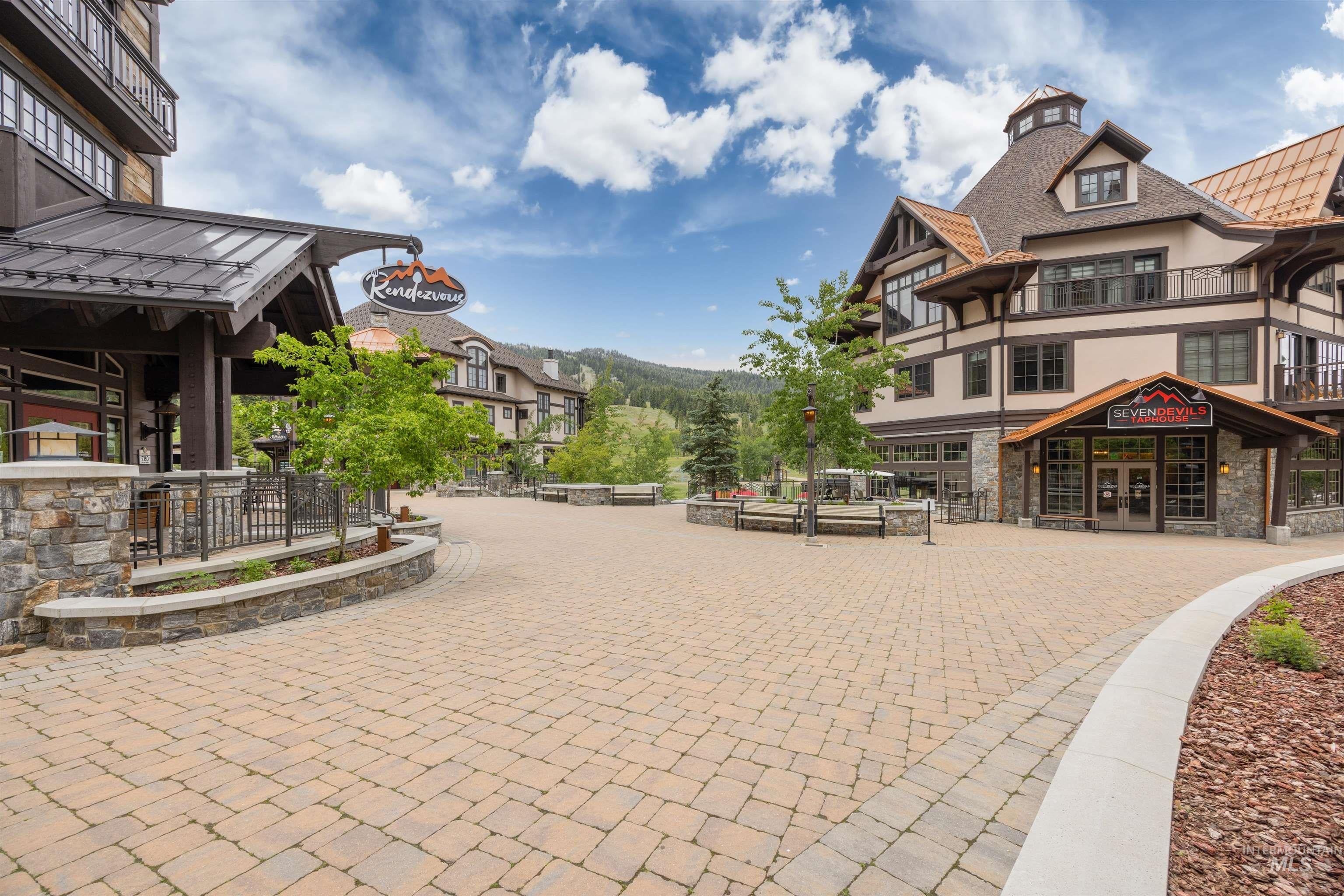 Expansive paved courtyard featuring herringbone-patterned pavers and integrated landscaping