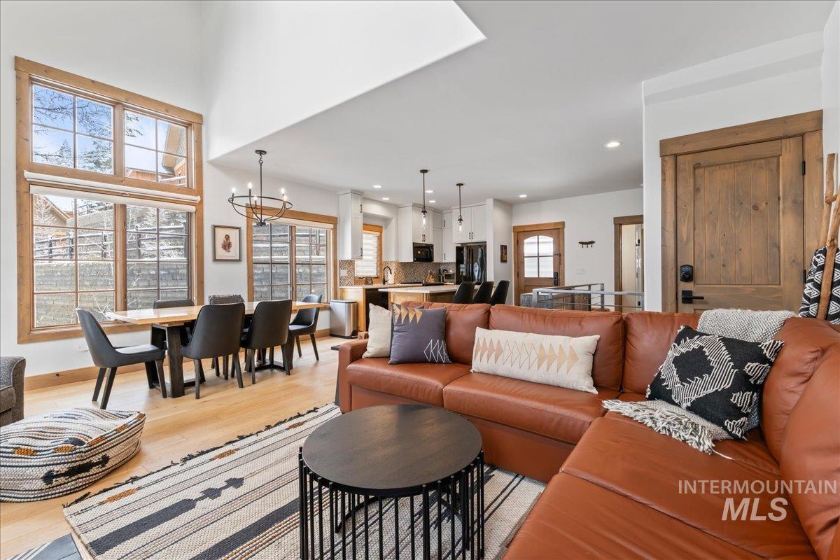 Living area with light wood-type flooring and suspended lighting
