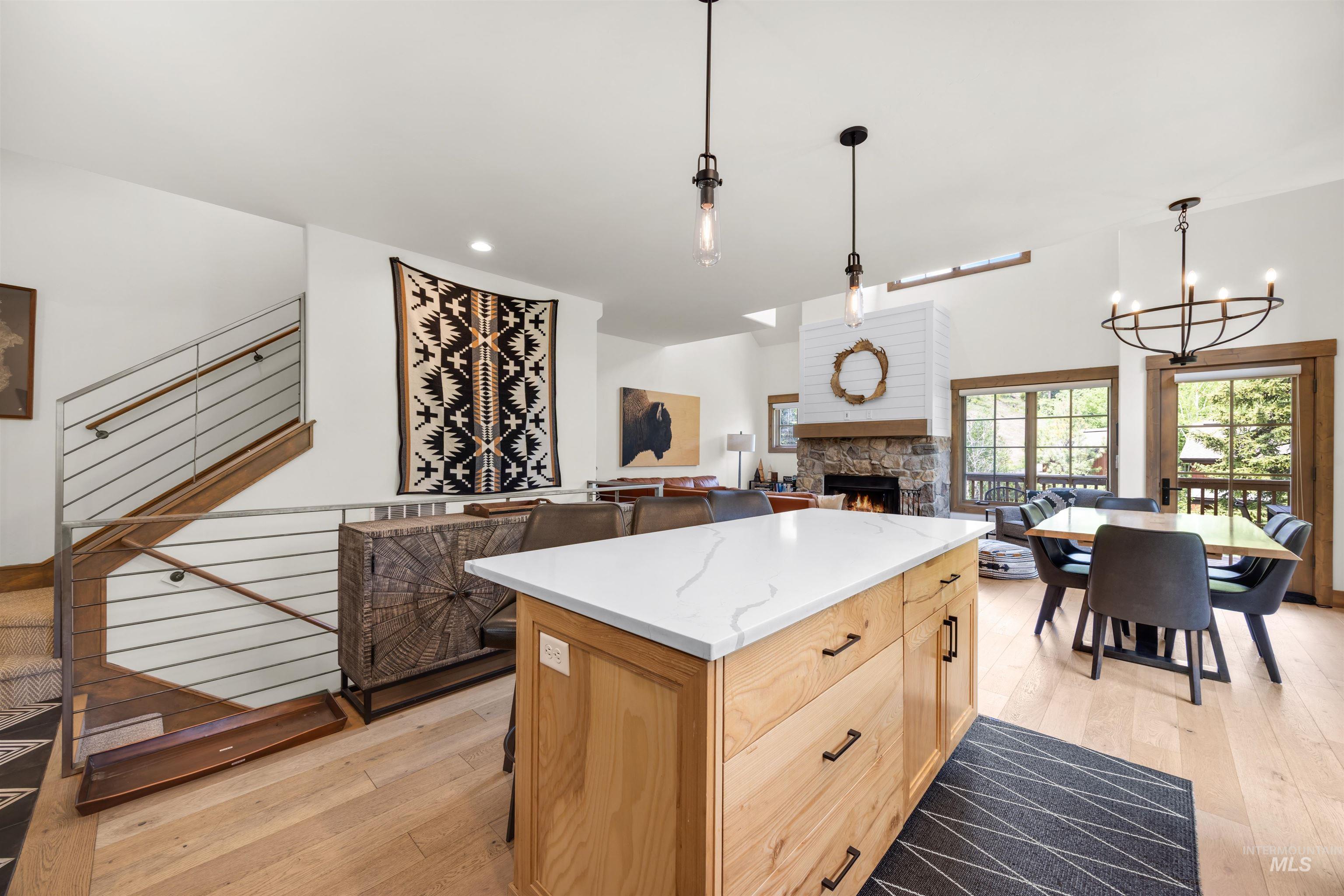 Kitchen island with a white countertop and light wood-finish cabinetry, complemented by wood-finish flooring