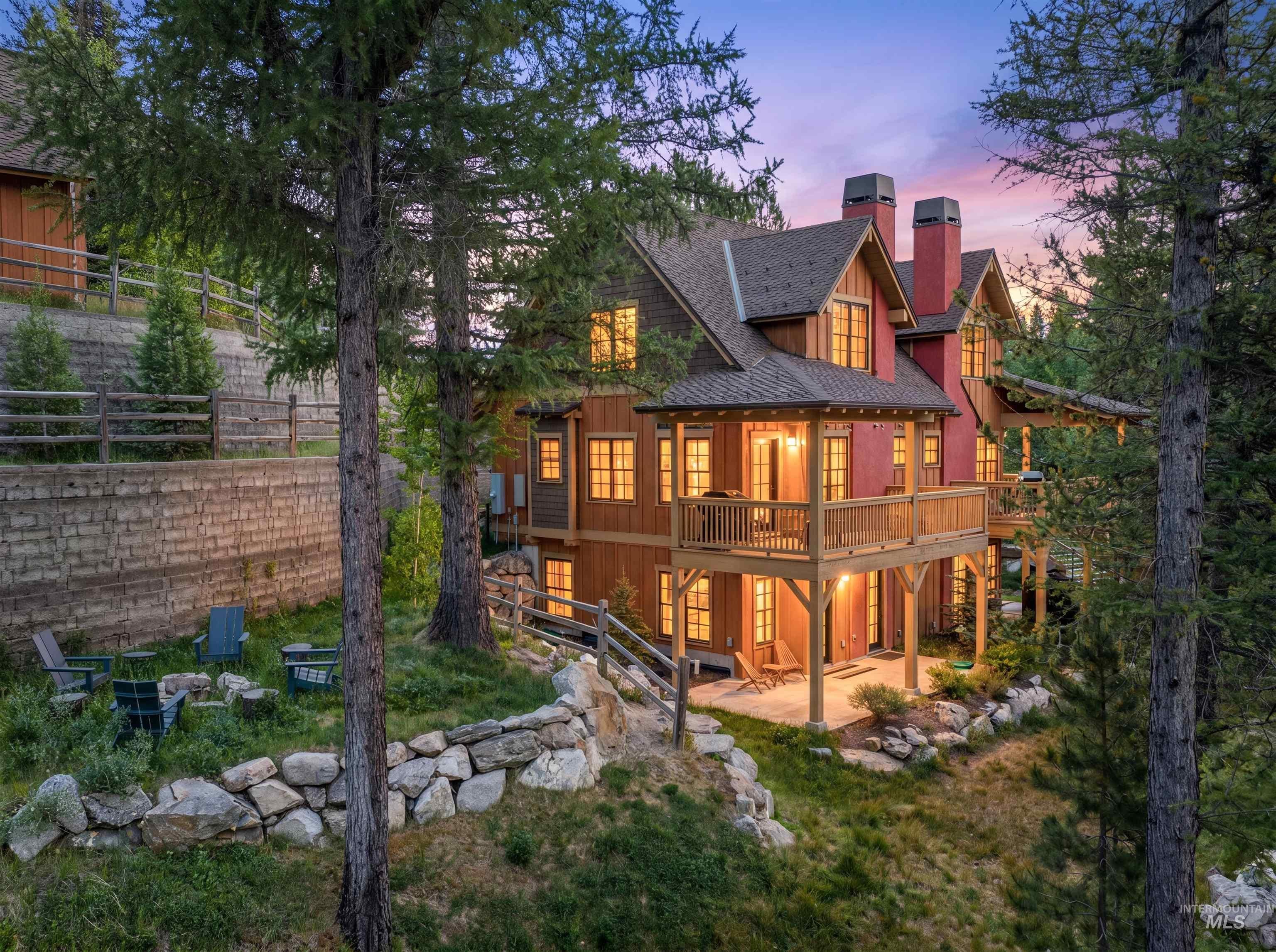 Rustic-style residence featuring a wooden exterior, multiple balconies, and prominent red chimneys
