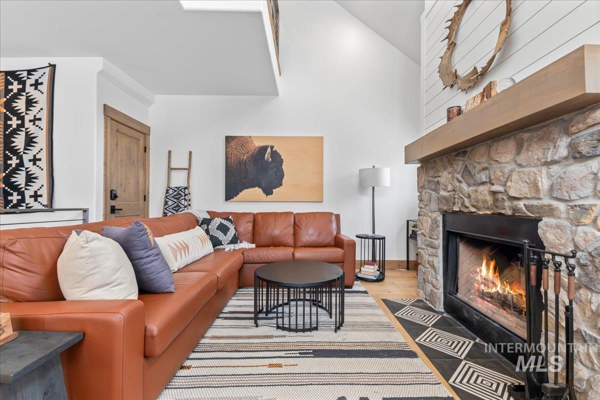 Living room featuring lofted ceiling, a fireplace, and light wood-type flooring