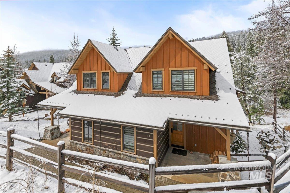 View of front of home with board and batten siding and a fenced front yard