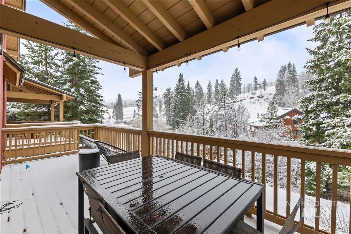 Snow covered deck featuring outdoor dining space