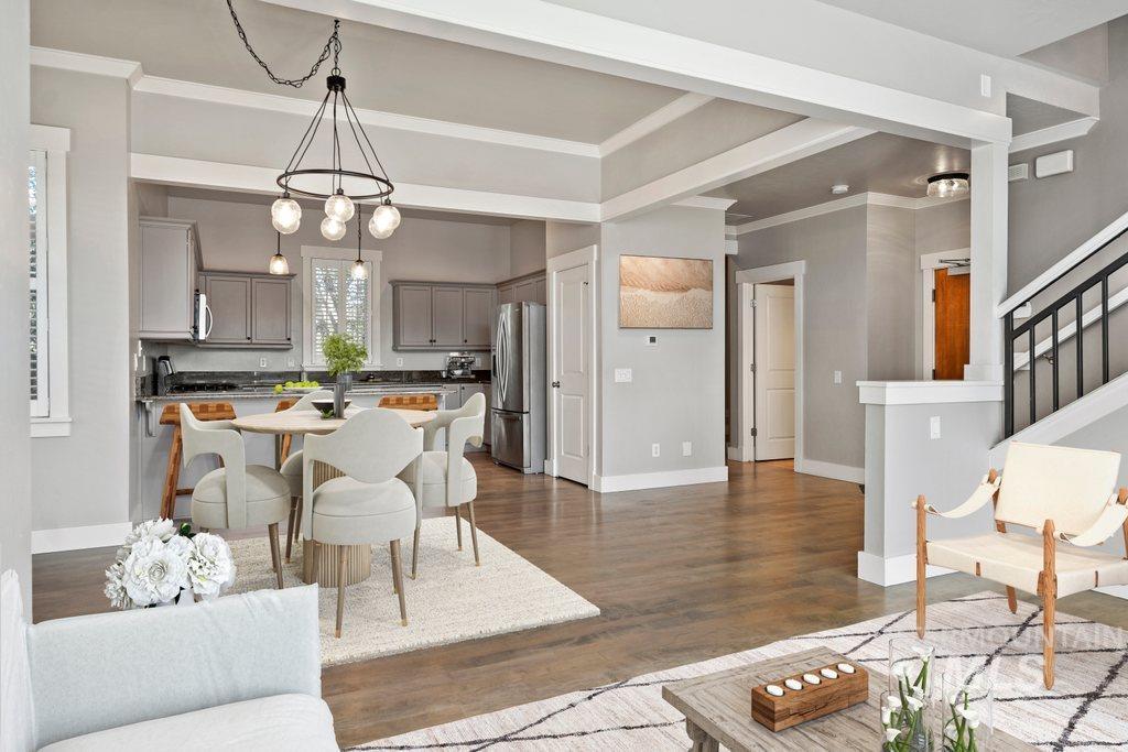 Living room with ornamental molding, dark wood-type flooring, and stairway