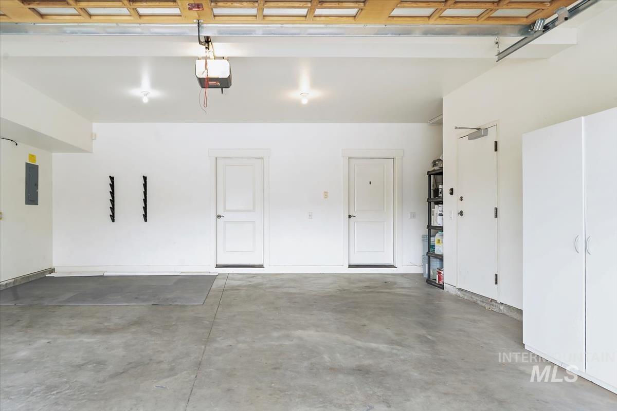 Garage featuring electric panel and a garage door opener