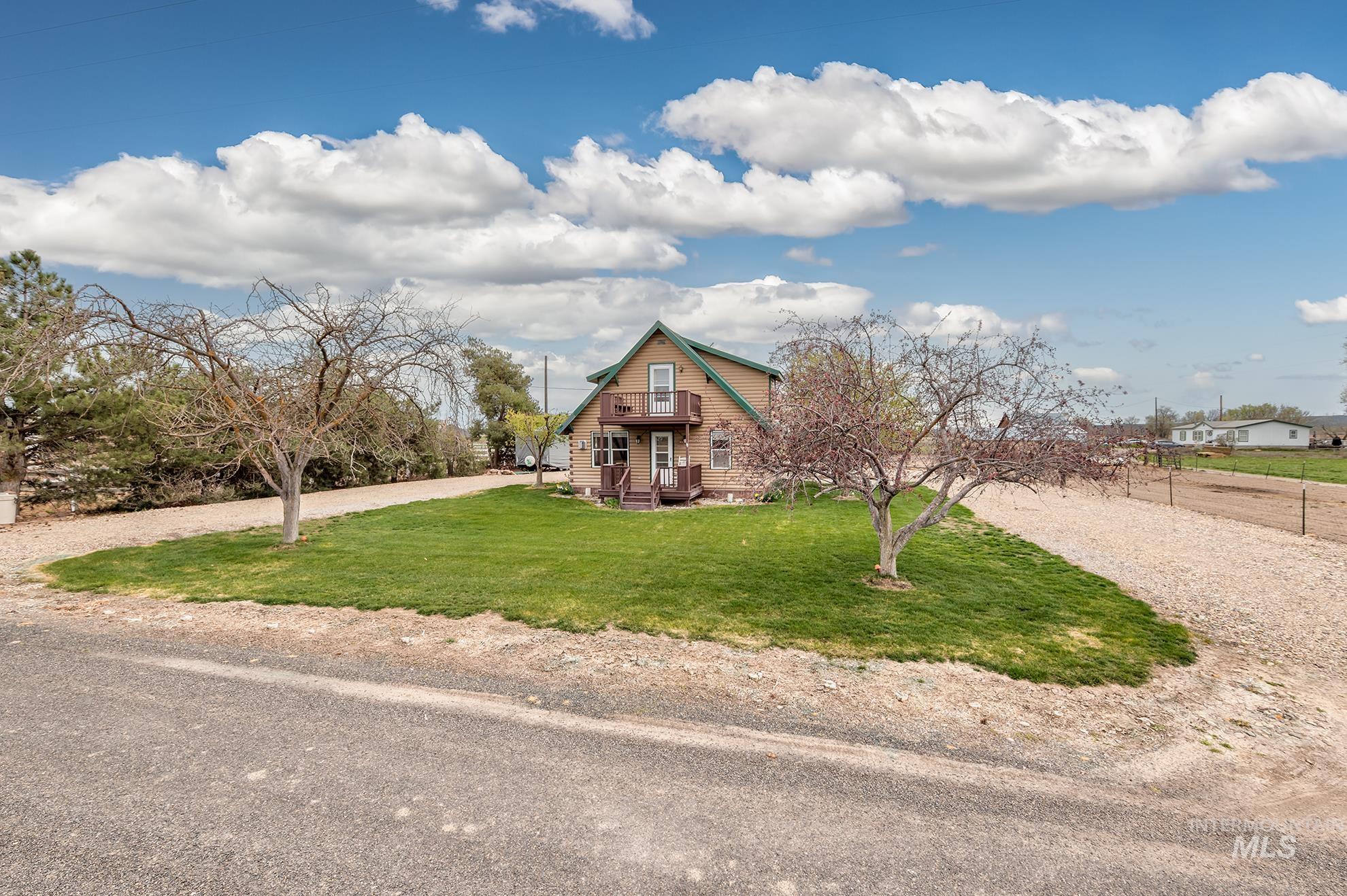 View of front facade with a front lawn and gravel driveway