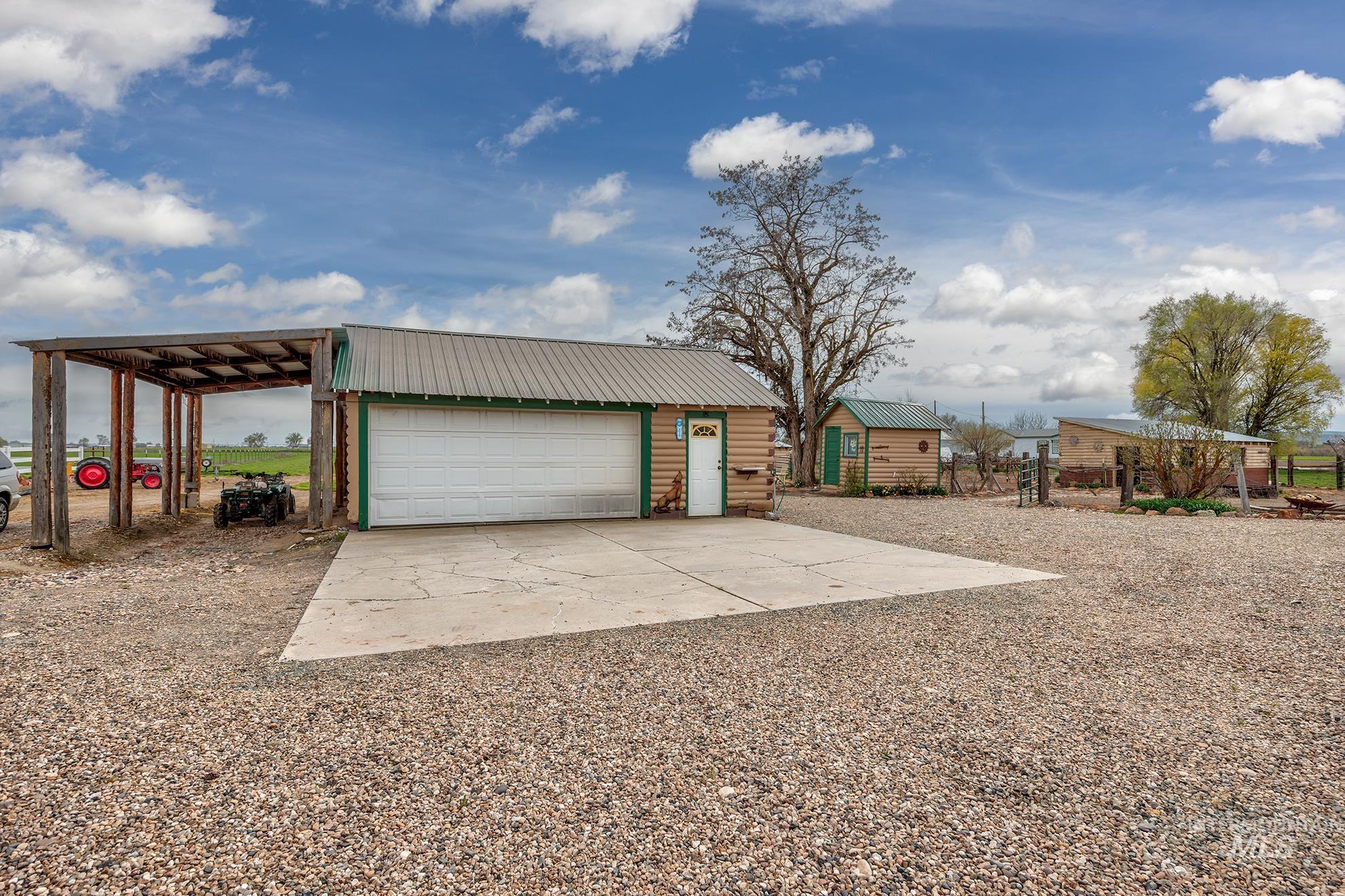 View of front of home featuring an outdoor structure, a garage, and a metal roof