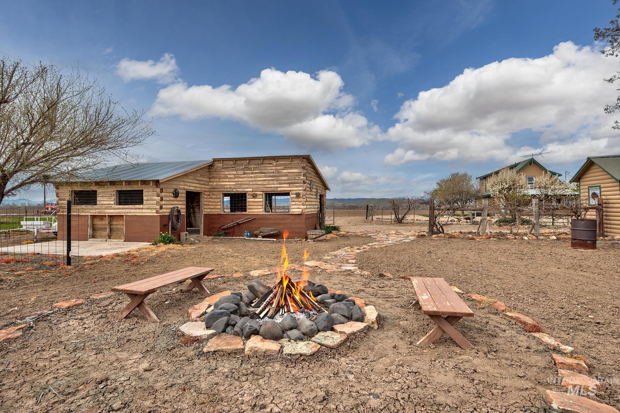 Rear view of property featuring a patio area, an outdoor fire pit, and a metal roof