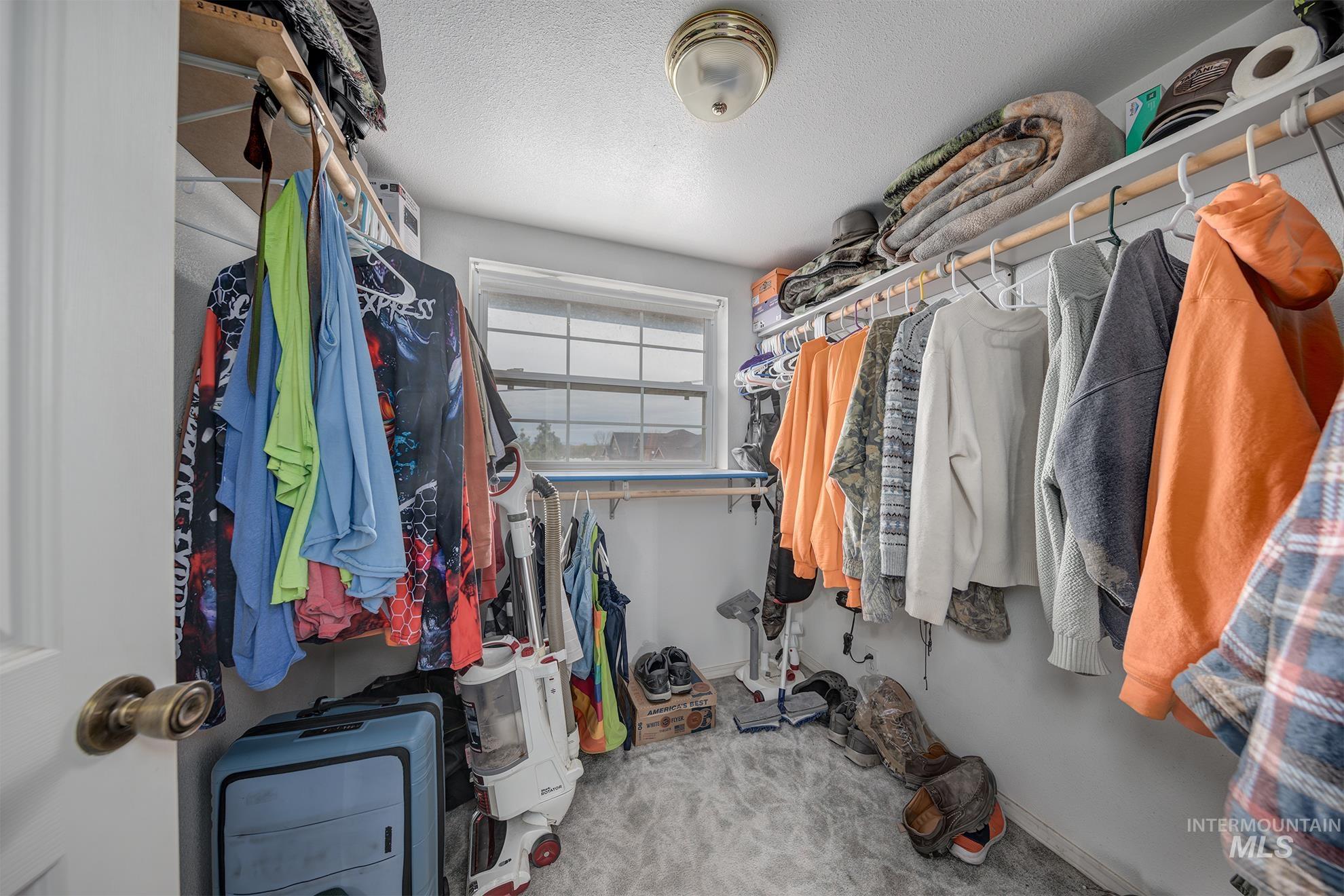 Walk in closet featuring light carpet