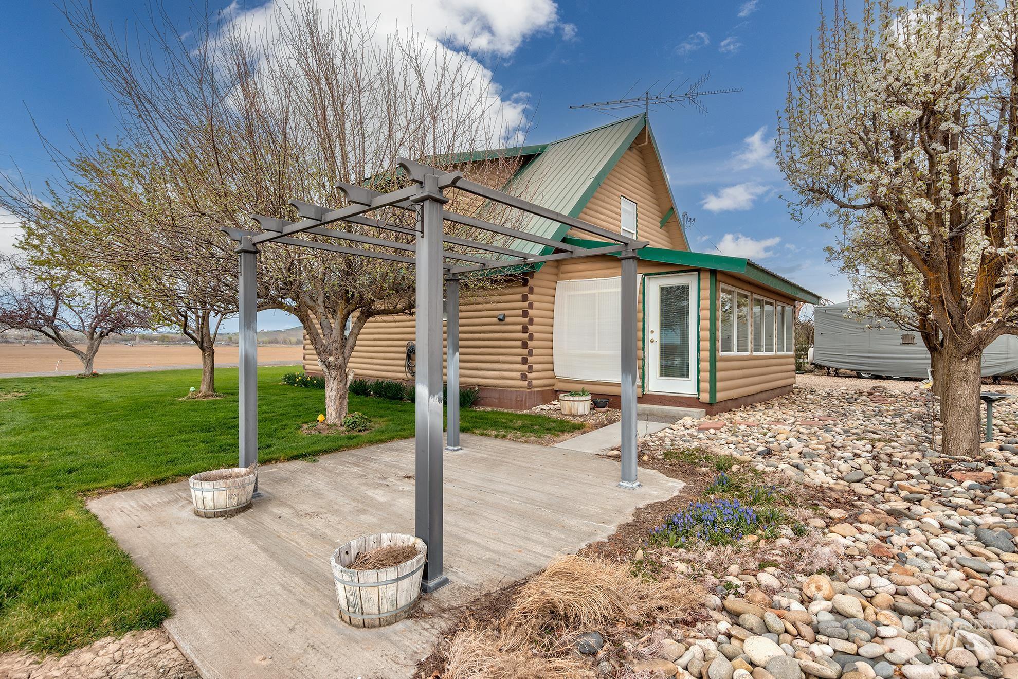 Exterior space featuring log exterior, a pergola, a yard, and a patio area